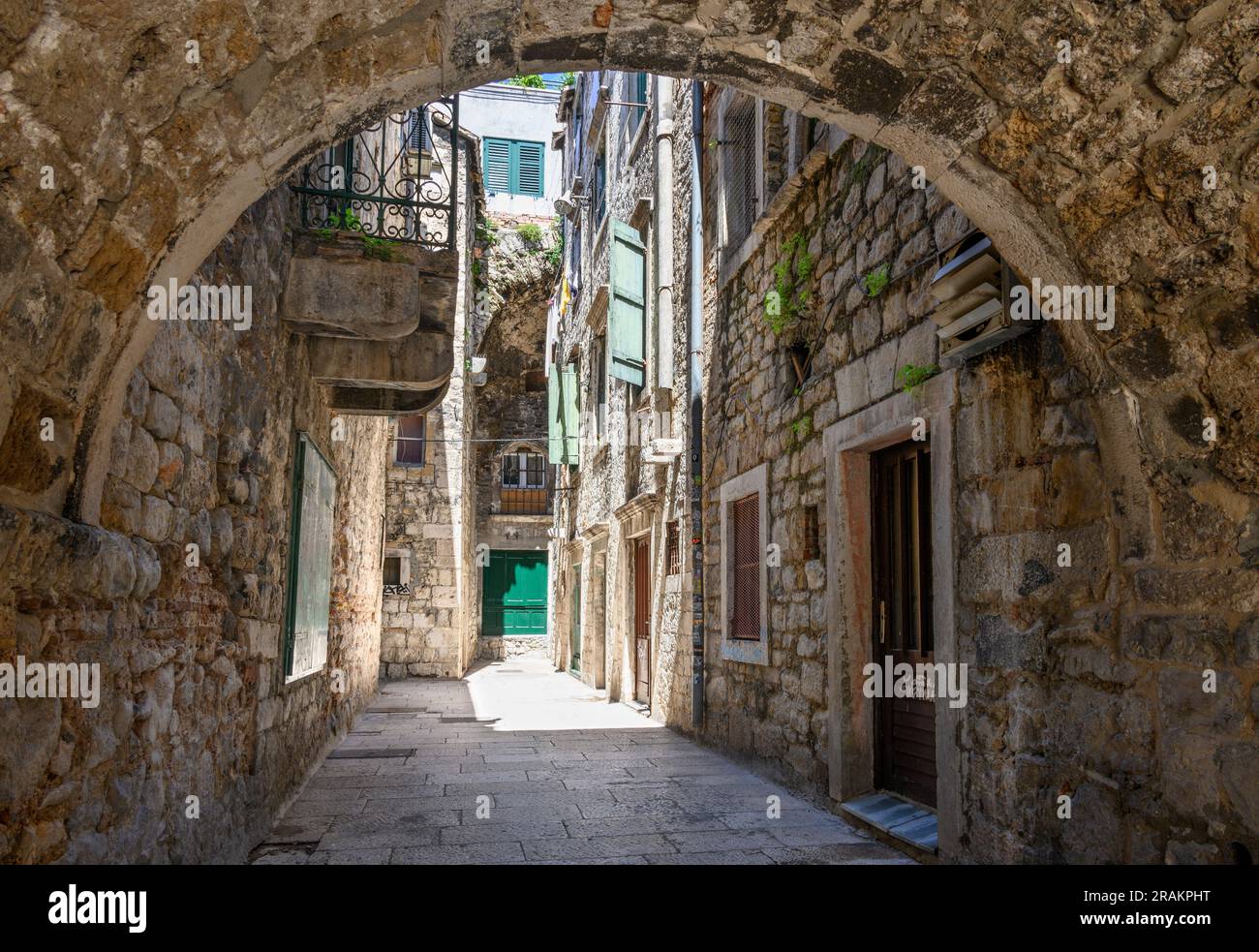 Eine typische überdachte, enge Gasse in der mittelalterlichen Altstadt neben den Mauern des Diokletianpalastes in Split, Dalmatien, Kroatien. Stockfoto