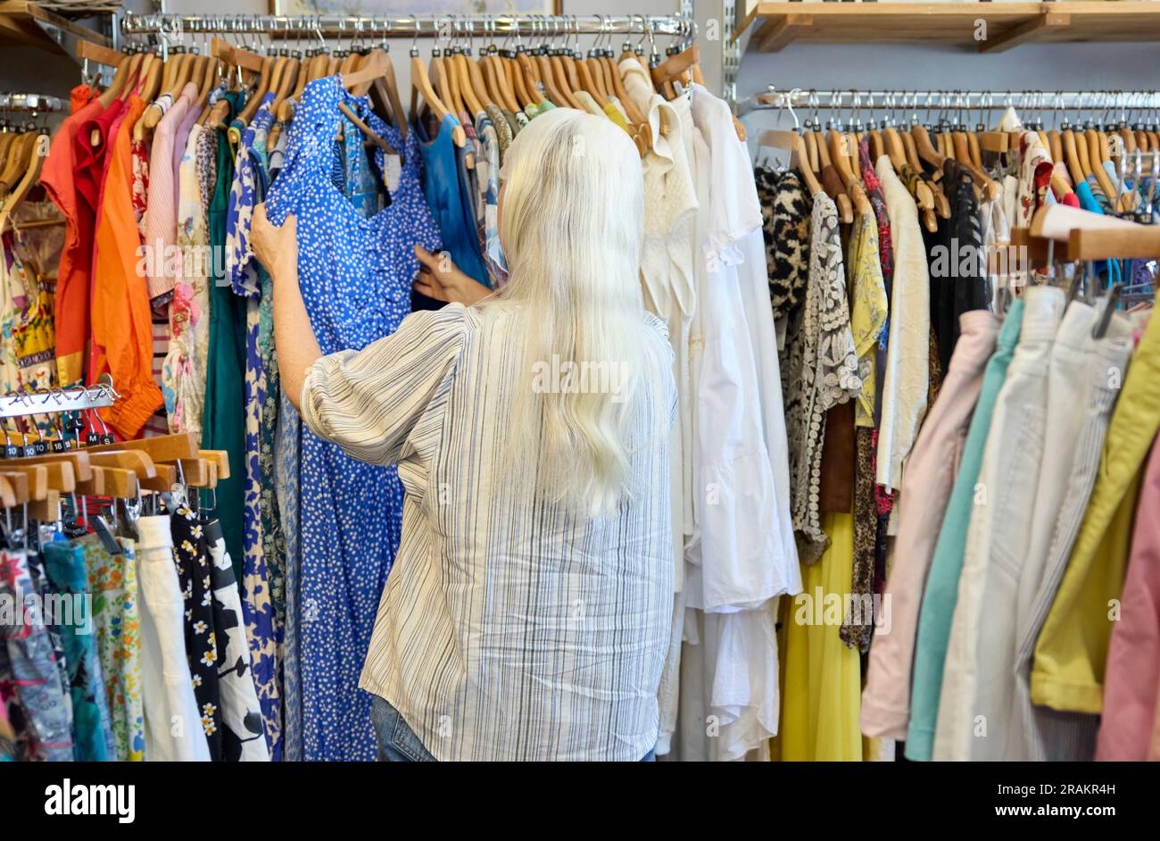 Rückansicht Einer Seniorin, Die Gebrauchte Nachhaltige Kleidung Aus Einem Second Hand Charity Shop Oder Thrift Store Kauft Stockfoto