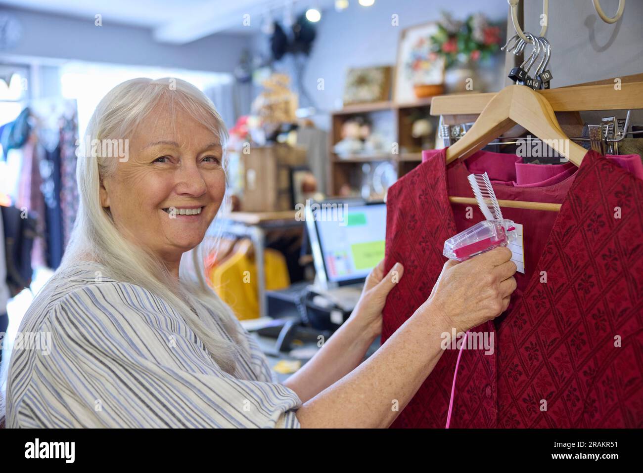 Porträt Einer Ehrenamtlichen Mitarbeiterin, Die In Einem Wohltätigkeitsladen Oder Einem Thrift Store Arbeitet Und Gebrauchte Und Nachhaltige Kleidung Verkauft Stockfoto