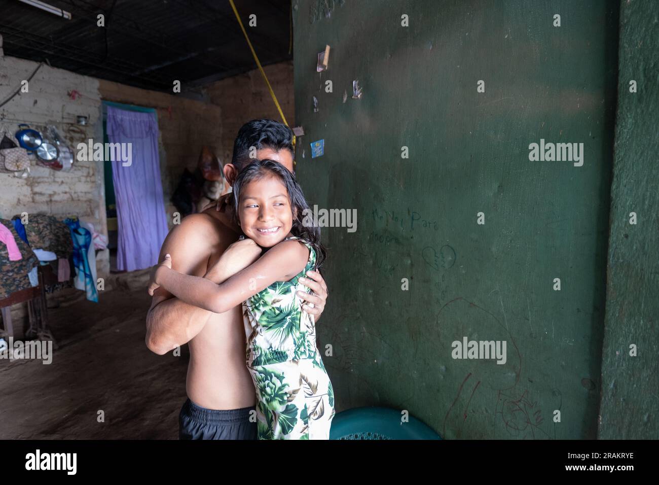 Ahuachapán, El Salvador - November 04 2022: Das kleine salvadorianische Mädchen umarmt ihren älteren Bruder Stockfoto