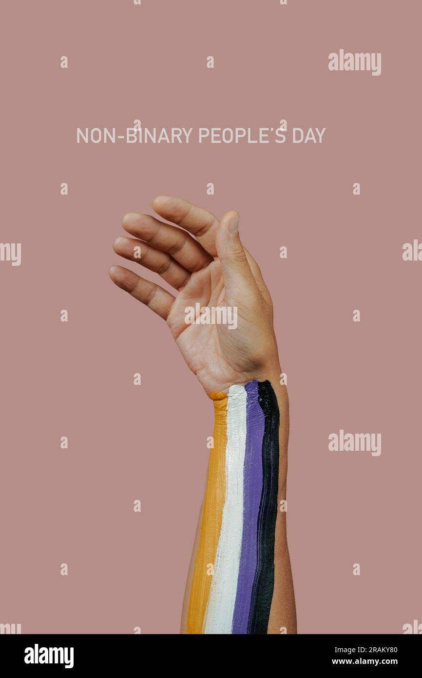 Der Text nicht-binäre Völker Tag und der Arm einer Person mit der nicht-binären Fahne auf pinkfarbenem Hintergrund Stockfoto