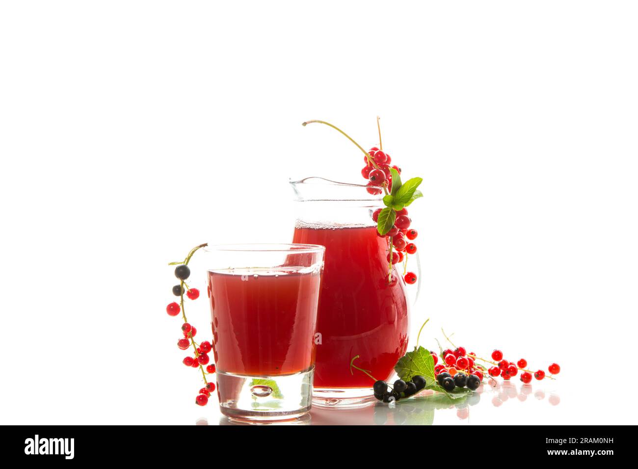 Frischer Beerensaft aus roter und schwarzer Johannisbeere, isoliert auf weißem Hintergrund Stockfoto