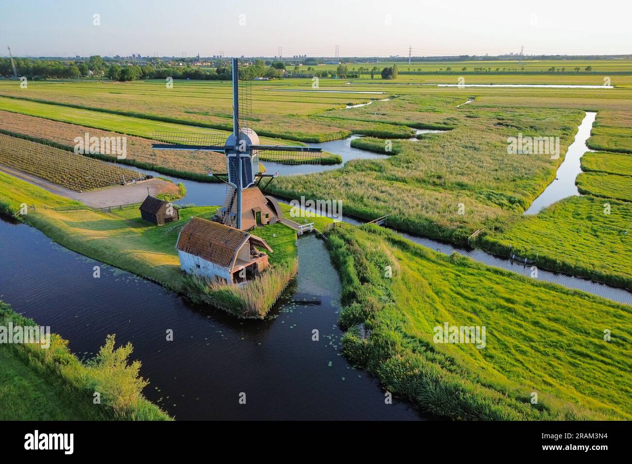 Traditionelle Windmühle in der breiten, offenen, wässrigen niederländischen Landschaft Stockfoto