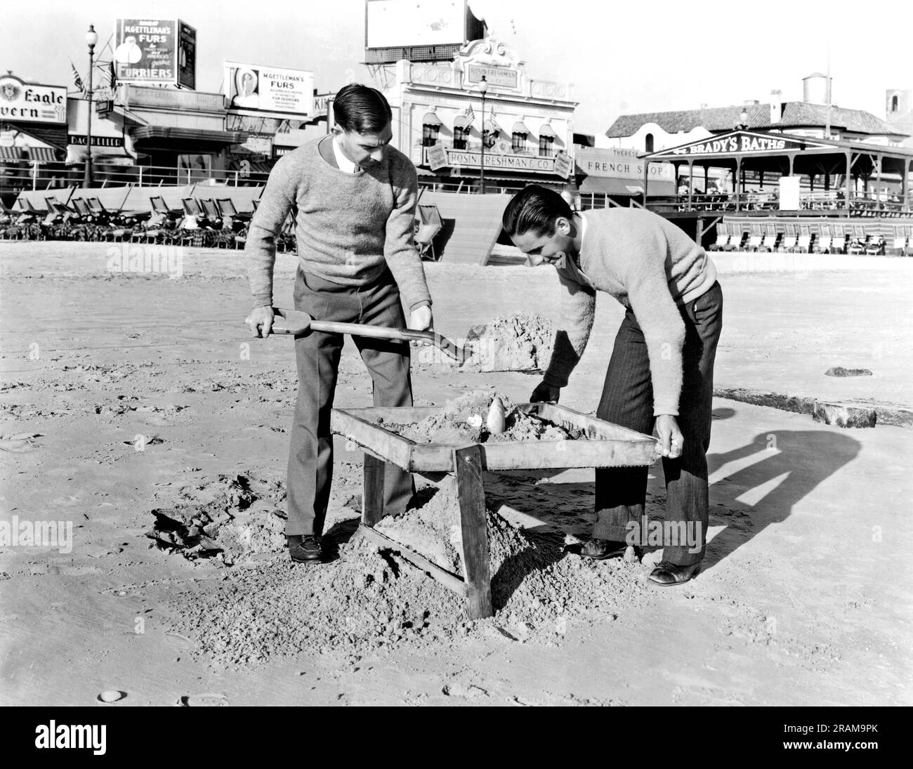 Atlantic City, New Jersey: ca. 1935. Arbeitslose College-Absolventen haben sich den Reihen von Strandgängern angeschlossen, die täglich den Sand von Atlantic City auf der Suche nach Wertsachen durchforsten, die von Millionen von Sommerbadern verloren wurden. Stockfoto