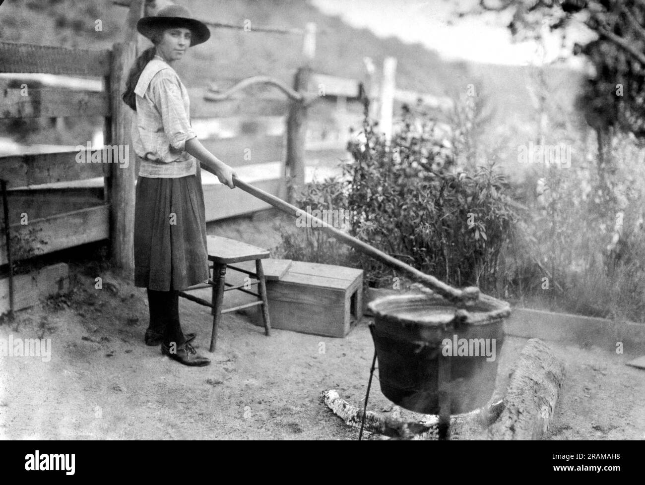 Little Orleans, Maryland: 28. Oktober 1920. Ein junges Mädchen, das Apfelbutter macht, so wie ihre Urgroßeltern sie vor Jahren gemacht haben. Sie verwendet denselben Eisentopf und Rührstab, der seit Jahren verwendet wird. Es ist einfach herzustellen und erfordert nur fünf Stunden kontinuierliches Rühren. Stockfoto