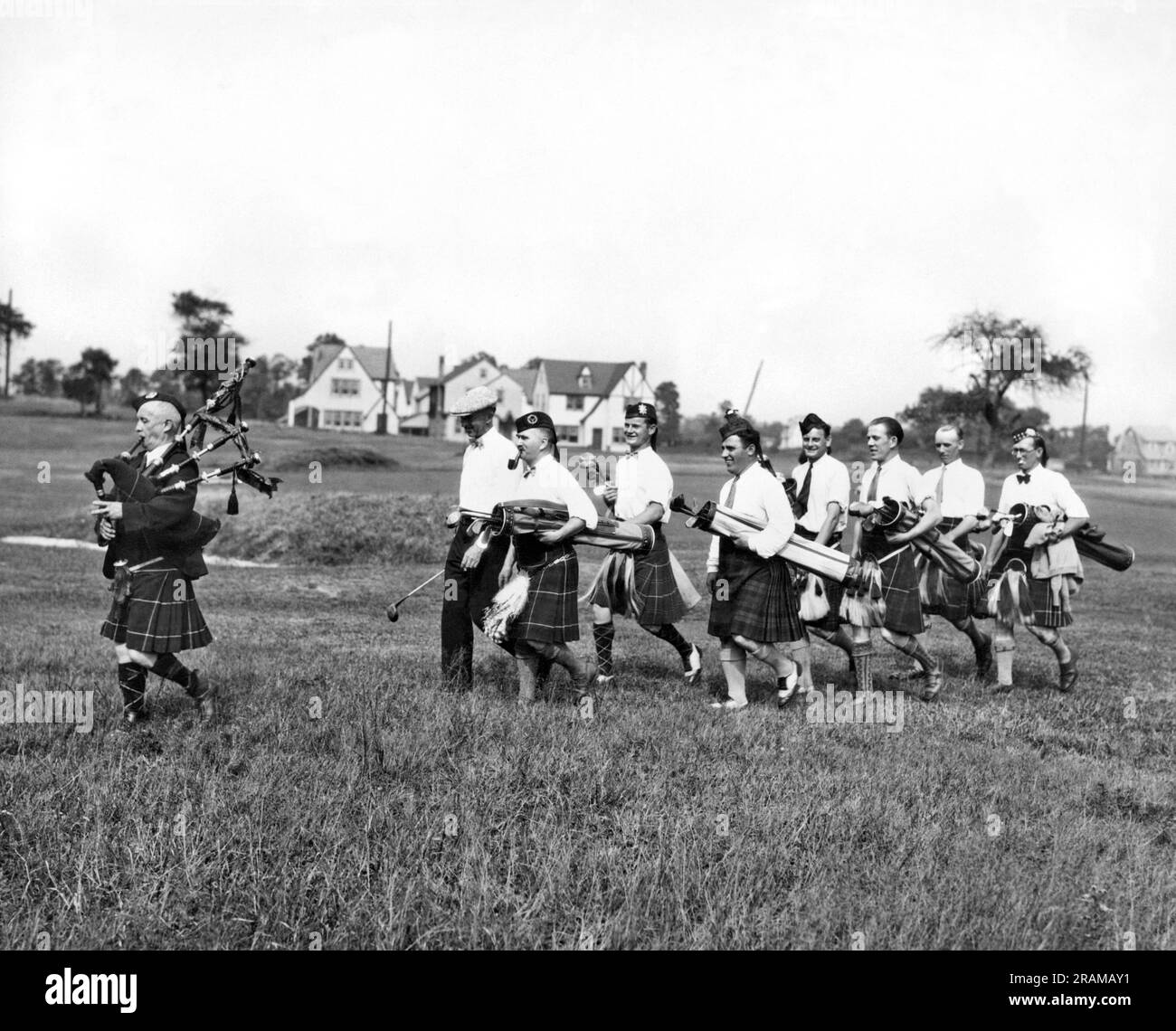 Linden, New York: ca. 1926. Mitglieder des NY Caledonian Club marschieren zwischen Löchern zur Melodie des Dudelsackpfeifers im Sunnyfield Club in Linden, NY. Stockfoto