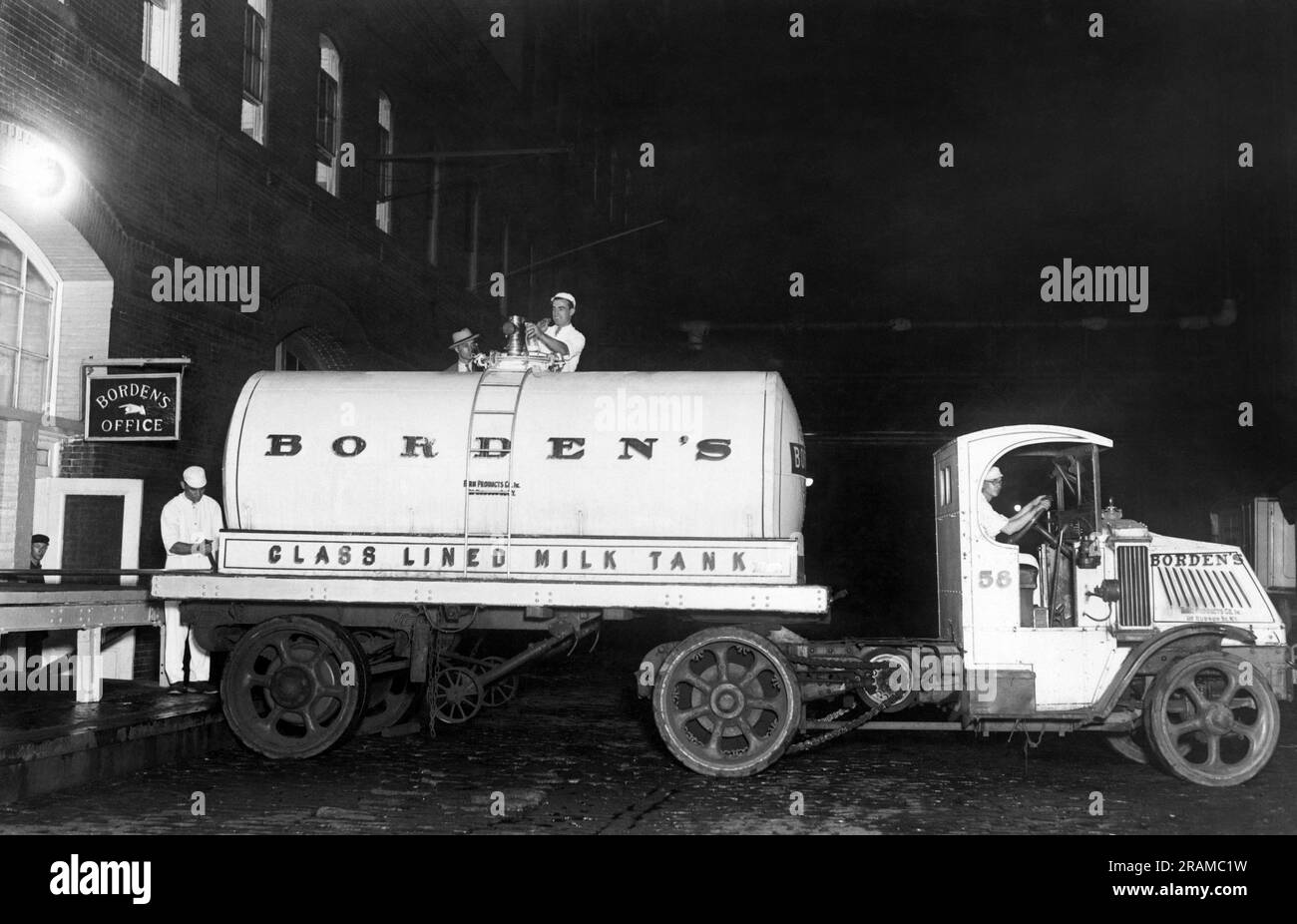 New York, New York: c. 1928 Ein neuer Milchtransporter von Borden mit dem Neuesten im Milchtransport. Der Lkw ist mit einem nahtlosen Glasbehälter mit Korkbezug ausgestattet, der die Milch for16 Stunden ohne Eis bei 37 Grad hält. Es dauert nur zehn Minuten, um den Tank des 8000-Quart-Lkws aus dem Tank des Zuges zu laden. Im Gegensatz zur alten Methode, bei der drei Männer 45 Minuten brauchten, um 200 Dosen Milch zu laden. Hier entlädt der Milchwagen mit der Vakuumflasche die Milch in der Pasteuranlage. Stockfoto