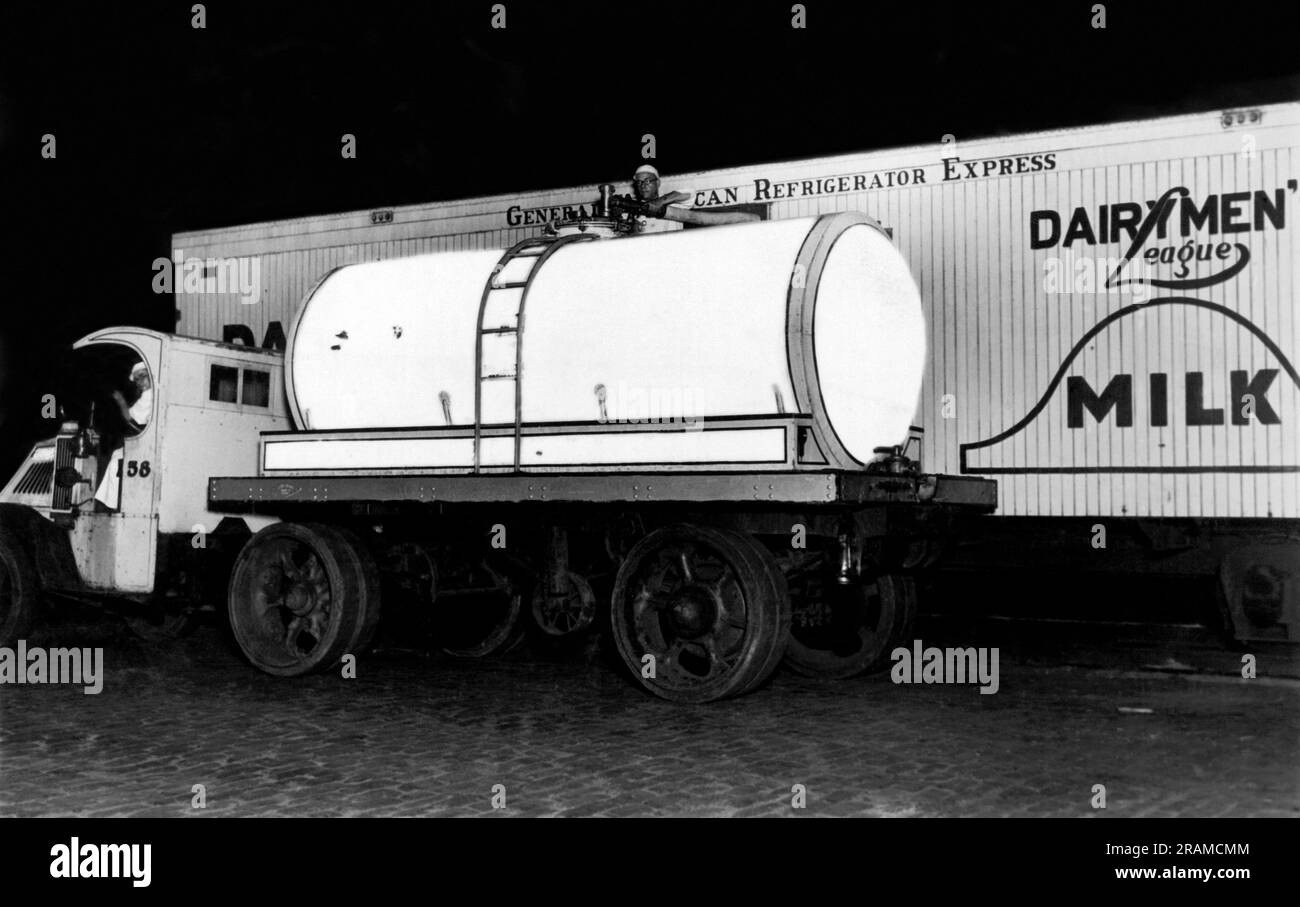 New York, New York: c. 1928 Ein neuer Milchtransporter von Borden zeigt das Neueste im Milchtransport. Sowohl der Lkw als auch der Zug sind mit nahtlosen Glasbehältern ausgestattet, die mit Kork bedeckt sind, die die Milch bei 37 Grad halten, for16 Stunden ohne Eis. Es dauert nur zehn Minuten, um den 8000-Quart-LKW-Tank aus dem Tank zu laden, Im Gegensatz zur alten Methode, bei der drei Männer 45 Minuten brauchten, um 200 Dosen Milch zu laden. Stockfoto