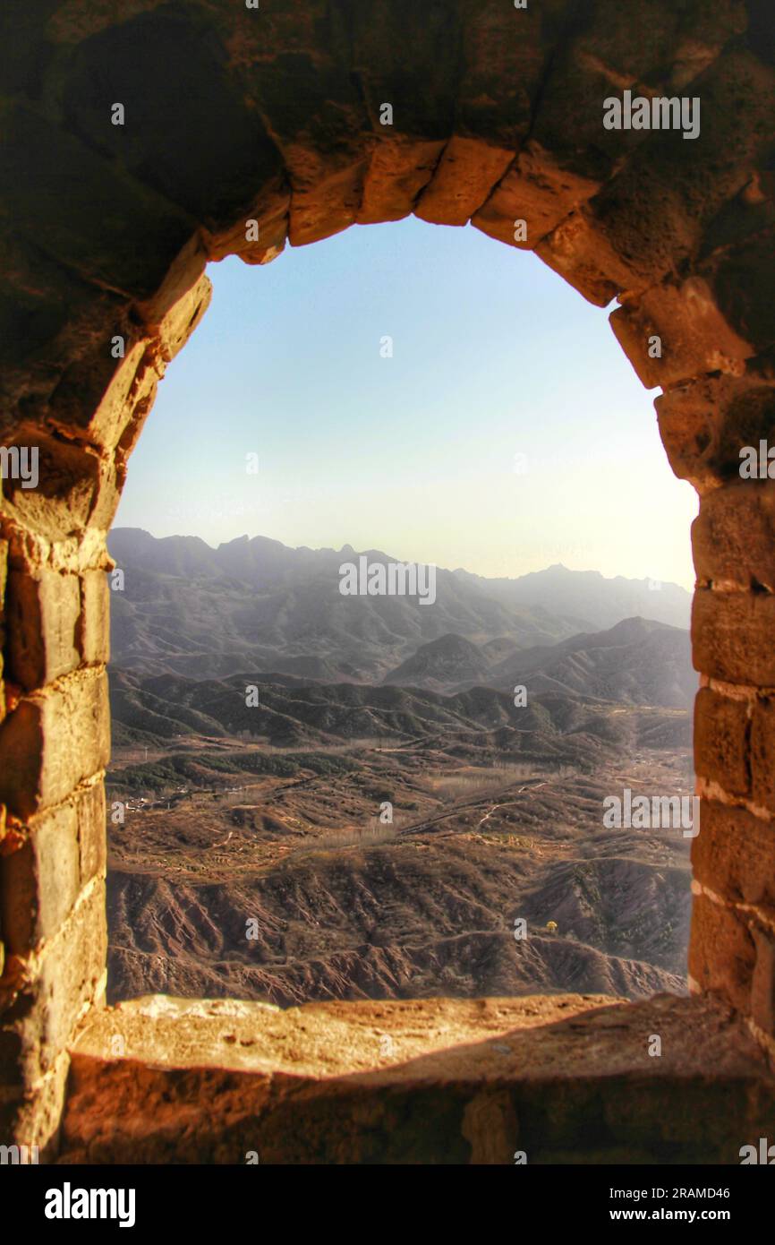 Erleben Sie die atemberaubende Aussicht von innen und von oben auf der majestätischen Chinesischen Mauer, gebadet in goldenem Sonnenlicht. Eine Reise durch uralte Pracht Stockfoto