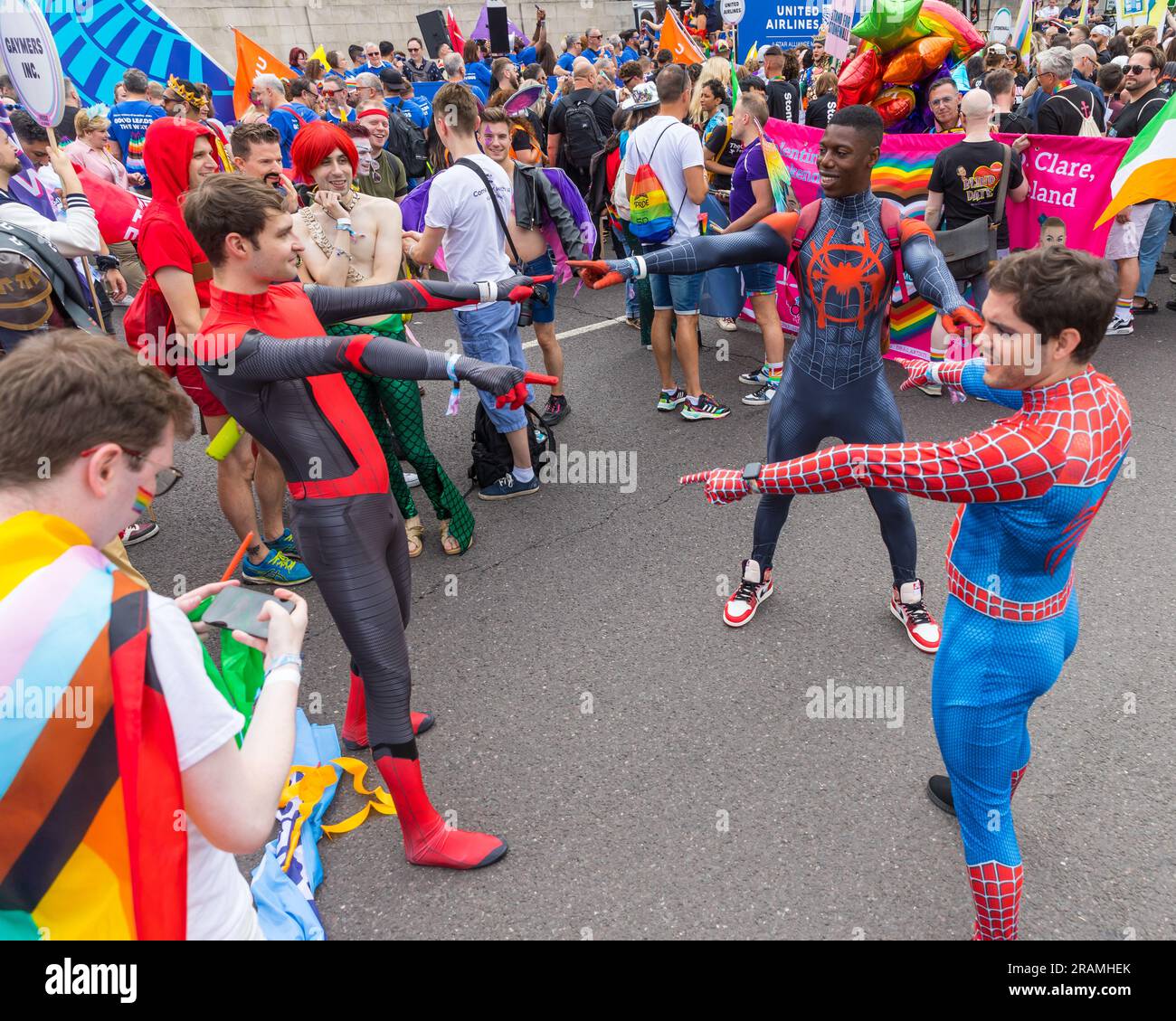 Drei Männer in Spiderman-Kostümen stellen während der "Pride in London"-Parade ein Zeigememe nach Stockfoto