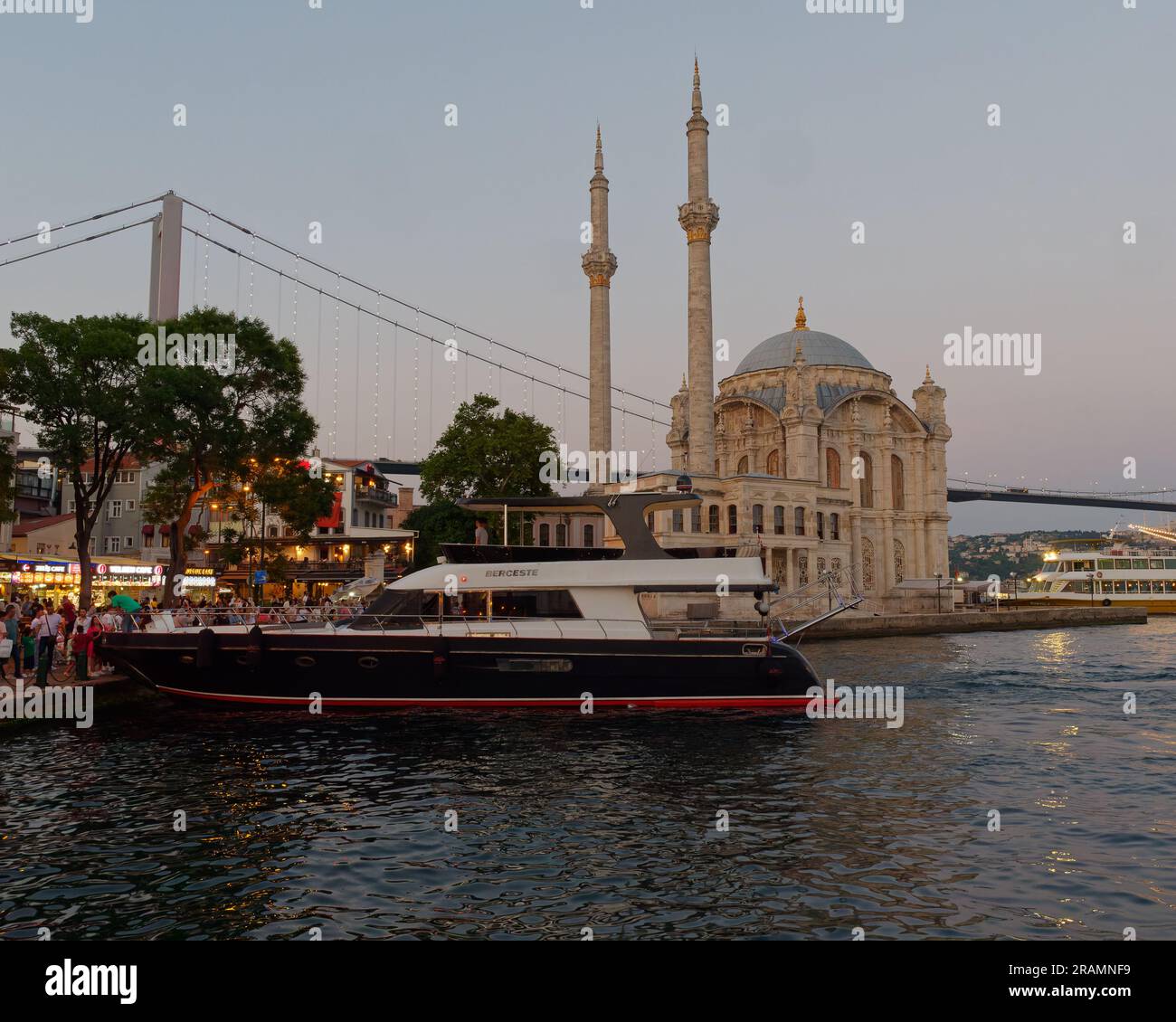 Luxusyacht an der Uferpromenade des Bosporus neben der Moschee im Stadtteil Ortaköy, Bezirk Beşiktaş, Istanbul, Türkei Stockfoto