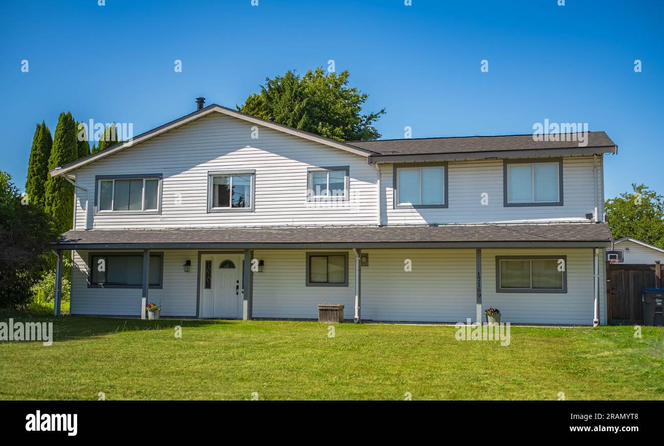 Wunderschönes Außengebäude in ländlicher Vorstadtgegend. Außenansicht des Real Estate Front House an einem sonnigen Tag. Großes Haus mit Vorgarten und grünem Rasen. Be Stockfoto