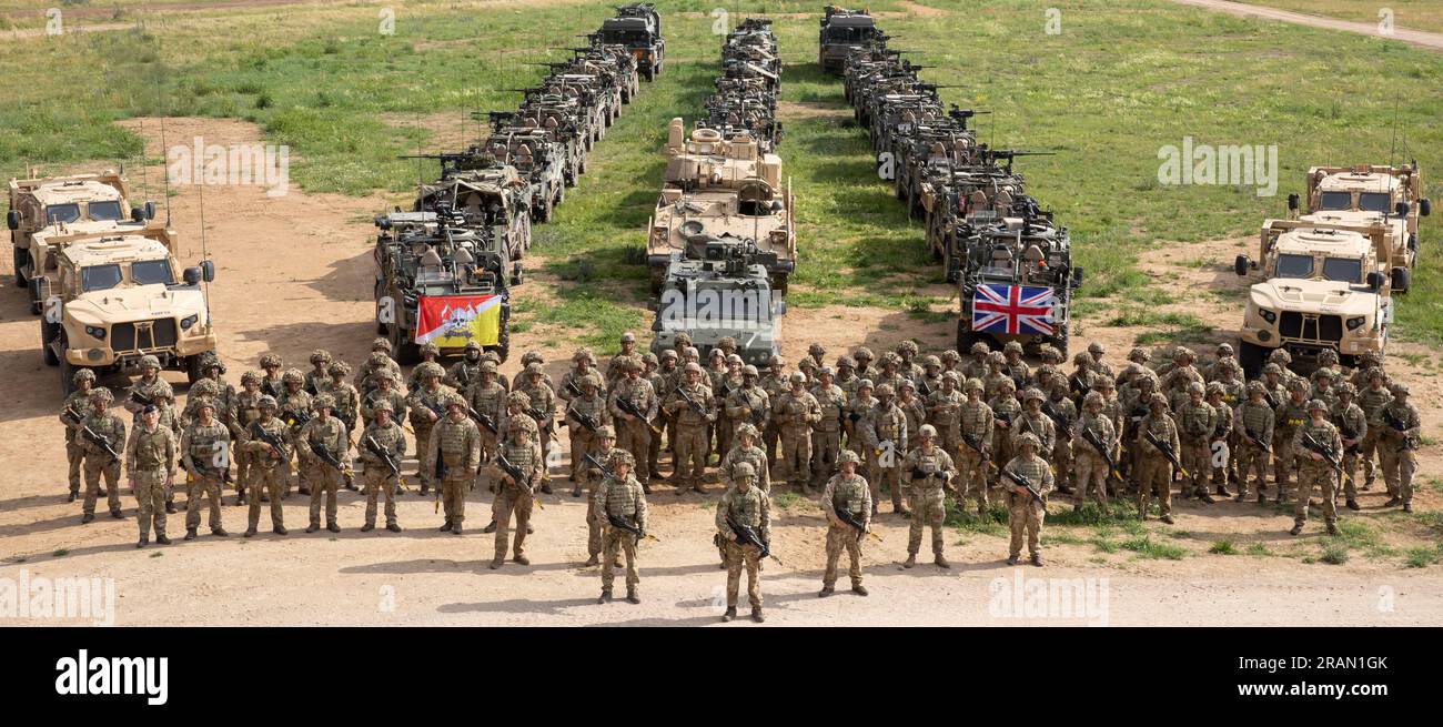 USA Soldaten mit Hauptquartier und Hauptquartier, 1. Bataillon, 9. Kavallerie-Regiment, 2. Bewaffnete Brigaden-Kampfeinheit, 1. Kavallerie-Division, die die 4. Infanterie-Division unterstützt, zusammen mit britischen Armeesoldaten im Vereinigten Königreich Royal Lancers, Aliwal-Truppe, die die verstärkte Front Presence Battle Group Poland der NATO unterstützt, posiert für ein Foto zum Abschluss der Operation Aliwal Surge im Ausbildungsgebiet Bemowo Piskie, Polen, Juli 3. Aliwal Surge war eine kurzfristige Bereitschaftsübung, mit der die Interoperabilität und Innovation der teilnehmenden militärischen Einheiten, einschließlich der amerikanischen Elle, getestet werden sollte Stockfoto