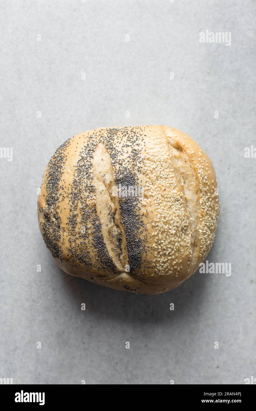 Draufsicht auf rundes hausgemachtes Brot auf einem Marmortablett, Potbrood mit Sesamsamen beschichtet Stockfoto