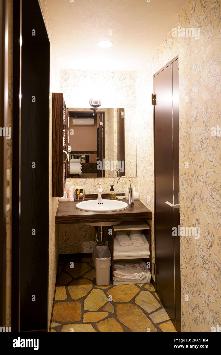 Badezimmer im japanischen Stil mit Keramikwaschbecken und Spiegel Stockfoto