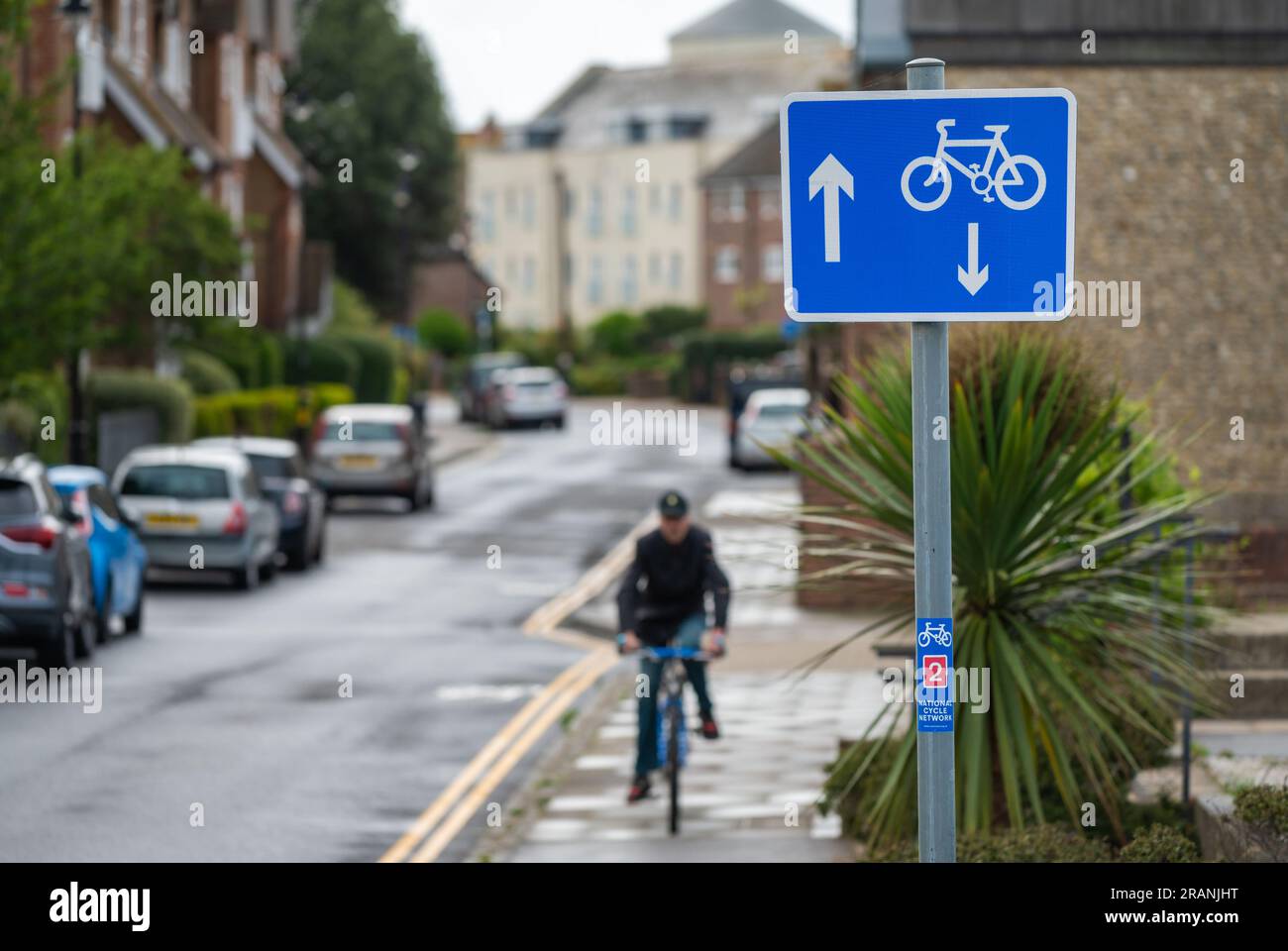 Hinweisschild mit Radfahrer auf einer Einbahnstraße, britische Straße, 2 Wege für Radfahrer, aber 1 Weg für Autos. In England, Großbritannien. Stockfoto