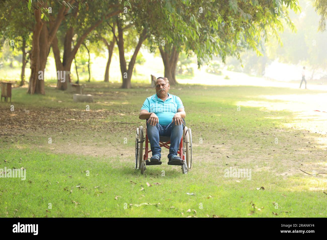 Indischer Seniorpatient im Krankenhausgarten auf dem Rollstuhl sitzend. Der Patient ist im Freien nicht in der Frischluftatmosphäre zu gehen. Stockfoto