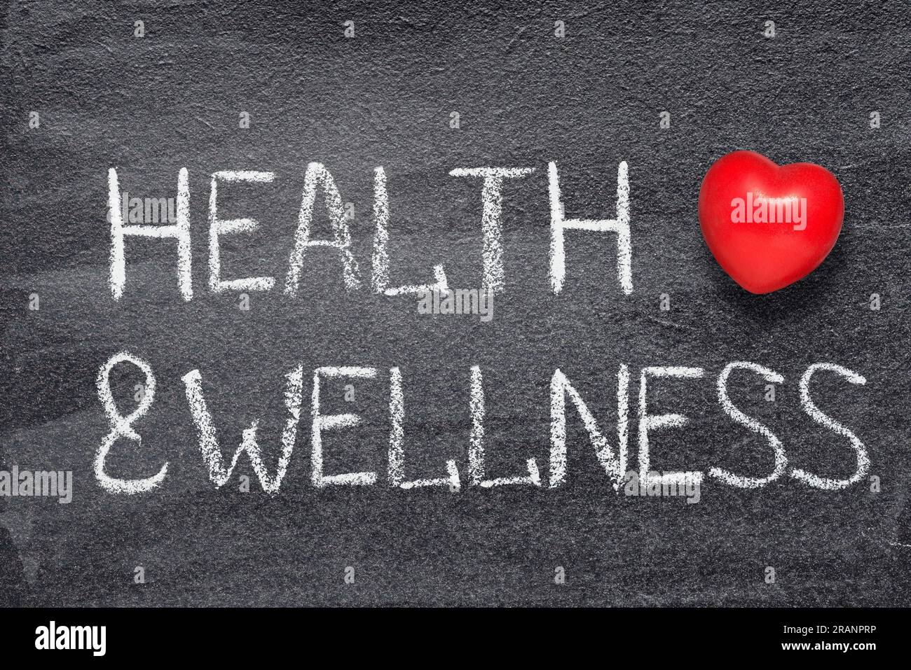 Gesundheits- und Wellness-Wörter auf der Tafel mit rotem Herzsymbol Stockfoto