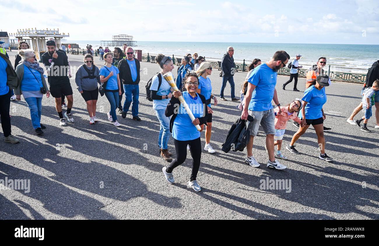 Brighton UK 5. . Juli 2023 - Bena Patel ist das erste Unternehmen , das den Baton of Hope entlang der Küste von Hove trägt , während es seine 2-wöchige Tour durch Städte in ganz Großbritannien fortsetzt , um das Bewusstsein für Selbstmord zu schärfen . Alle teilnehmenden Freiwilligen wurden von Selbstmord betroffen. #BatonOfHopeUK ist die größte Selbstmordaufklärungs- und -Präventionsinitiative, die das Vereinigte Königreich je gesehen hat, da es der größte Mörder von Männern und Frauen unter 35 Jahren in Großbritannien ist : Credit Simon Dack / Alamy Live News Stockfoto