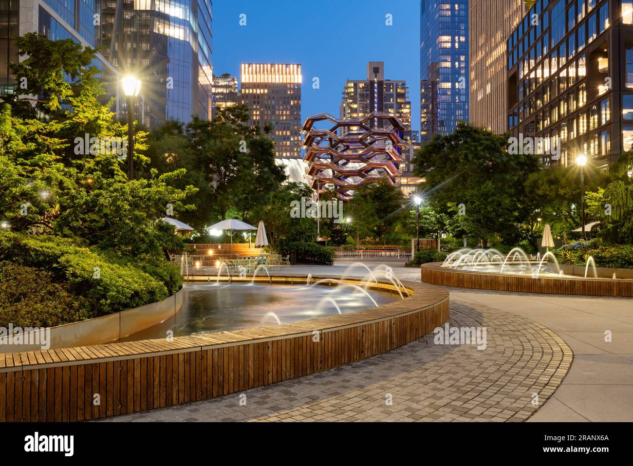 Park und Springbrunnen im Hudson Yards Gebäudekomplex am Abend. Sommer in Midtown West, Manhattan, New York City Stockfoto