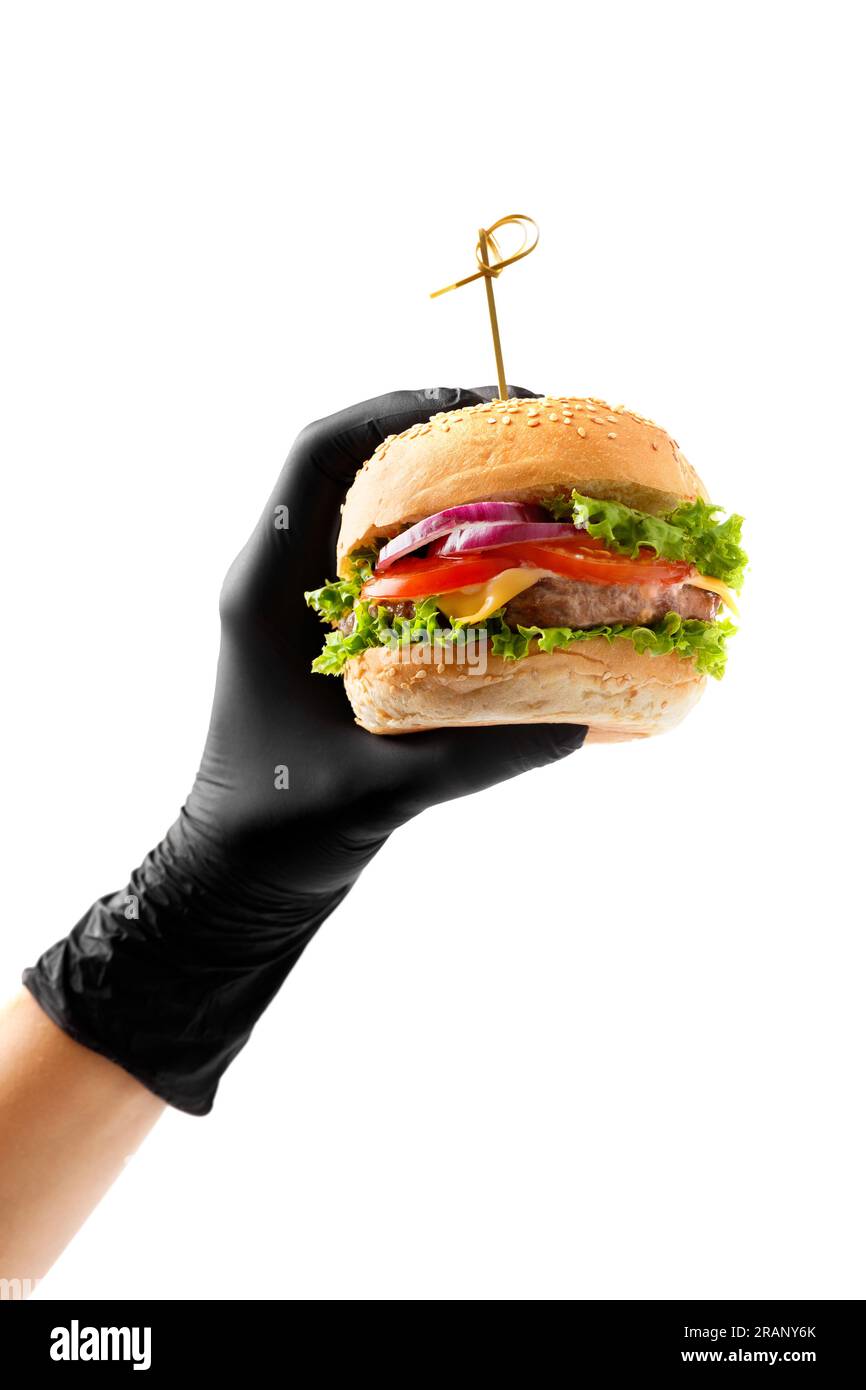 Eine Hand in einem schwarzen Handschuh hält einen saftigen, appetitlichen Rindfleischburger auf weißem Hintergrund. Hamburger in Händen isoliert. Banner, Fast-Food-Werbung. Stockfoto