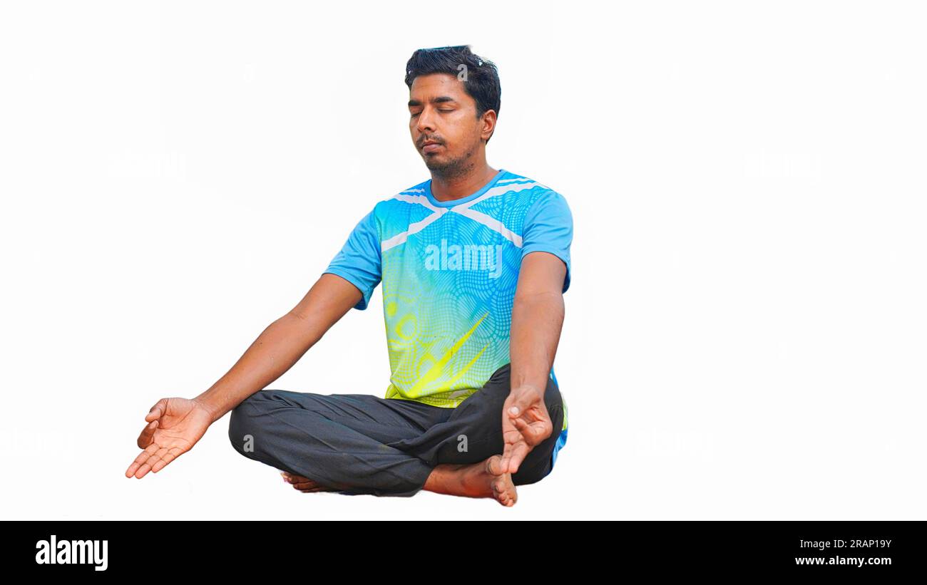 Junger indischer Mann in sportlichen Outfits, der Yoga macht und vor weißem Hintergrund meditiert Stockfoto