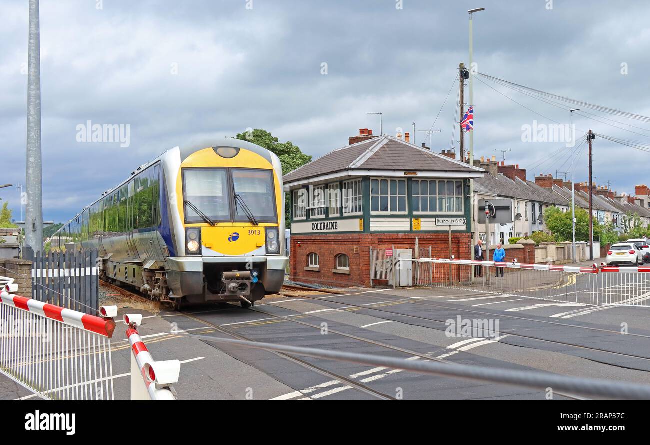 Der Zug der NI Railways fährt sicher über die Bahnübergänge in der Bushmills Rd, Coleraine, Northern Ireland, UK, BT52 2BN Stockfoto