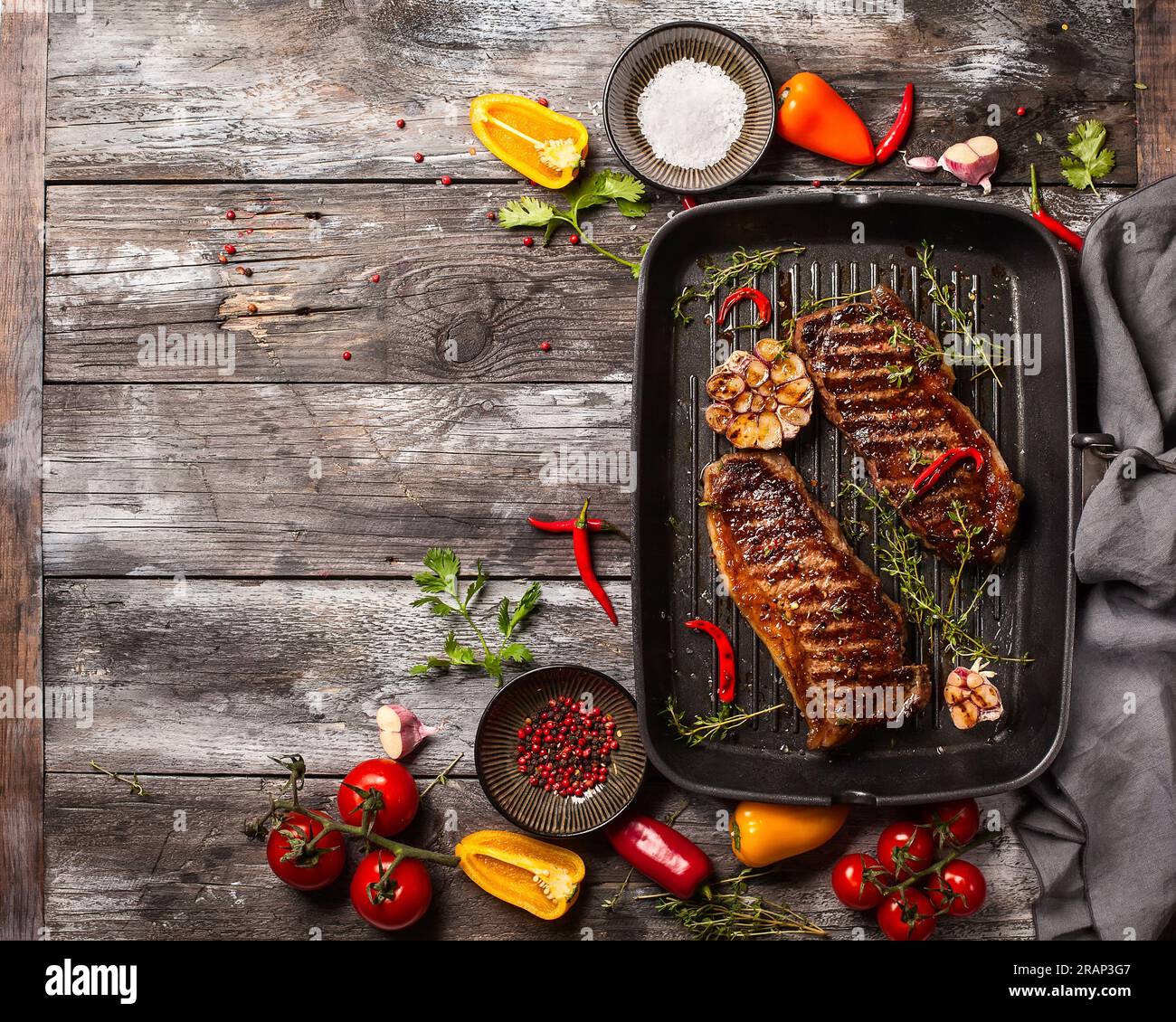 Gegrilltes Striploin Steak mit Gewürzen und Kräutern auf einer Eisentopf. Das Strip Steak, auch bekannt als New York Strip. Stockfoto