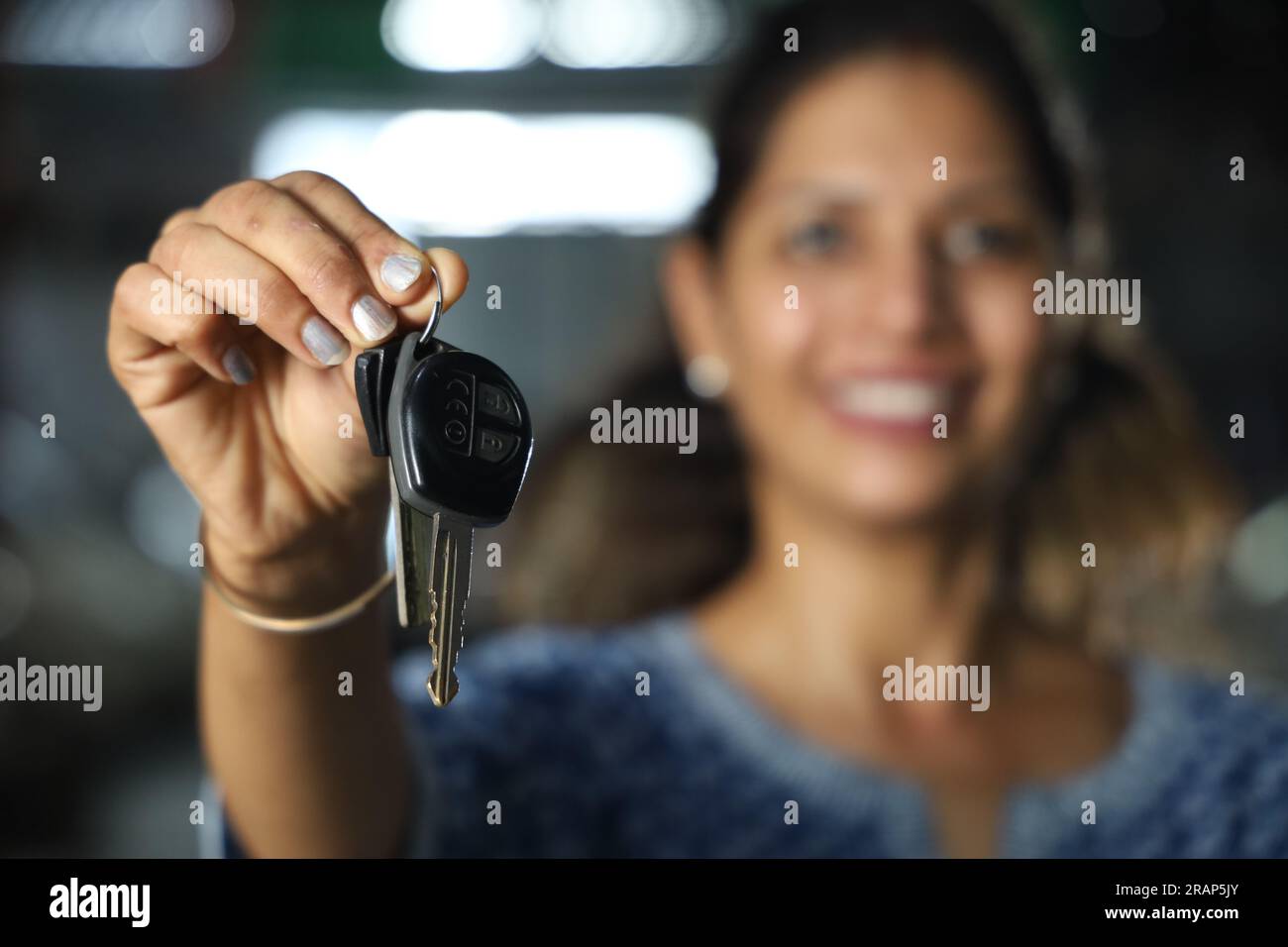 Ein indischer glücklicher Kunde gab dem Mechaniker die Autoschlüssel. Das Vertrauen der Kunden in die Tankstelle zu übertragen, ein fröhlicher Kunde Stockfoto