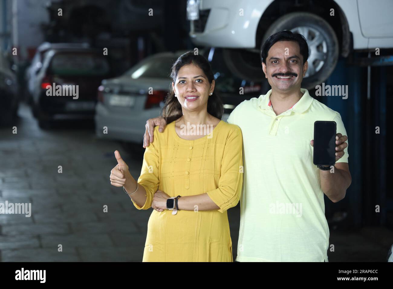 Indische zufriedene Kunden zeigen Daumen hoch, weil sie das Fahrzeug ehrlich repariert haben. Darstellung des Kundenvertrauens und der Kundenzufriedenheit gegenüber der Tankstelle Stockfoto