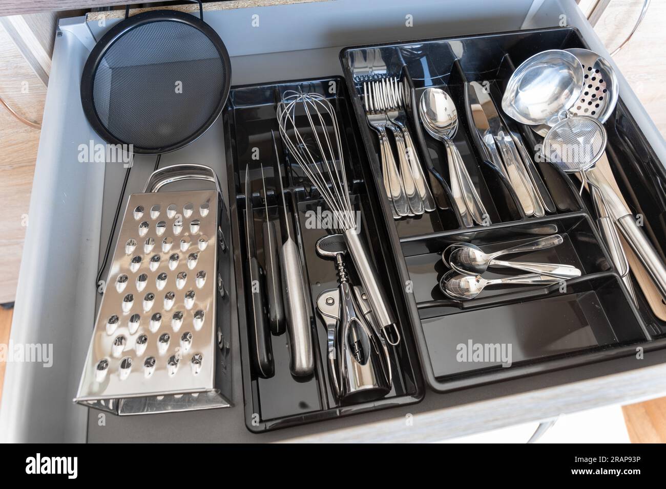 Schublade voll mit Metallbesteck Stockfoto