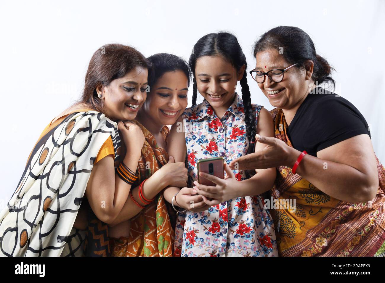 Ländliche indische glückliche Frauen in Saree, die Selfie machen und ein Video in einem Dorf machen. Das junge Mädchen hält ein Handy in der Hand Stockfoto