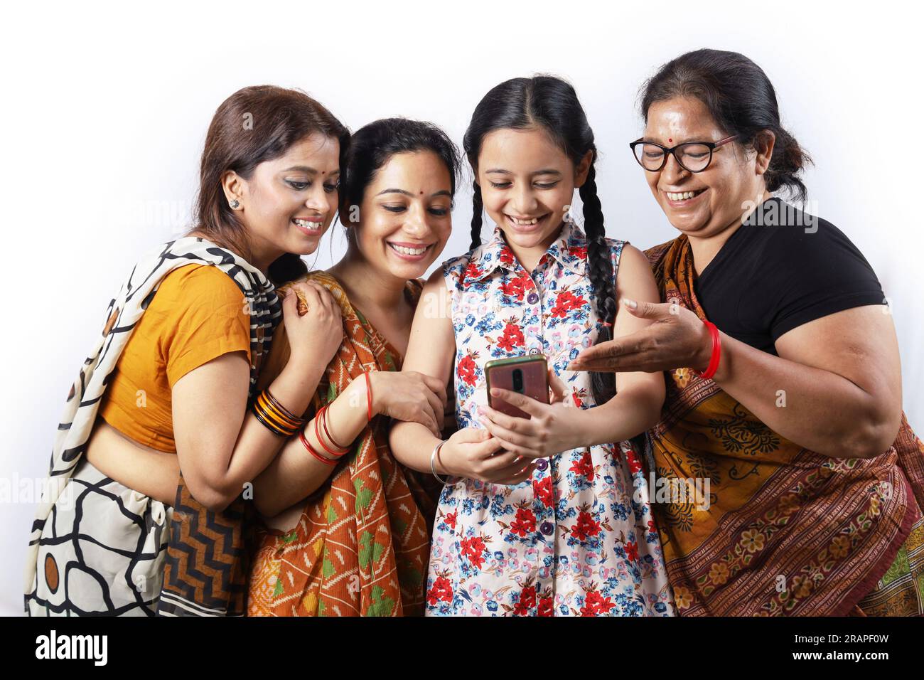 Ländliche indische glückliche Frauen in Saree, die Selfie machen und ein Video in einem Dorf machen. Das junge Mädchen hält ein Handy in der Hand Stockfoto