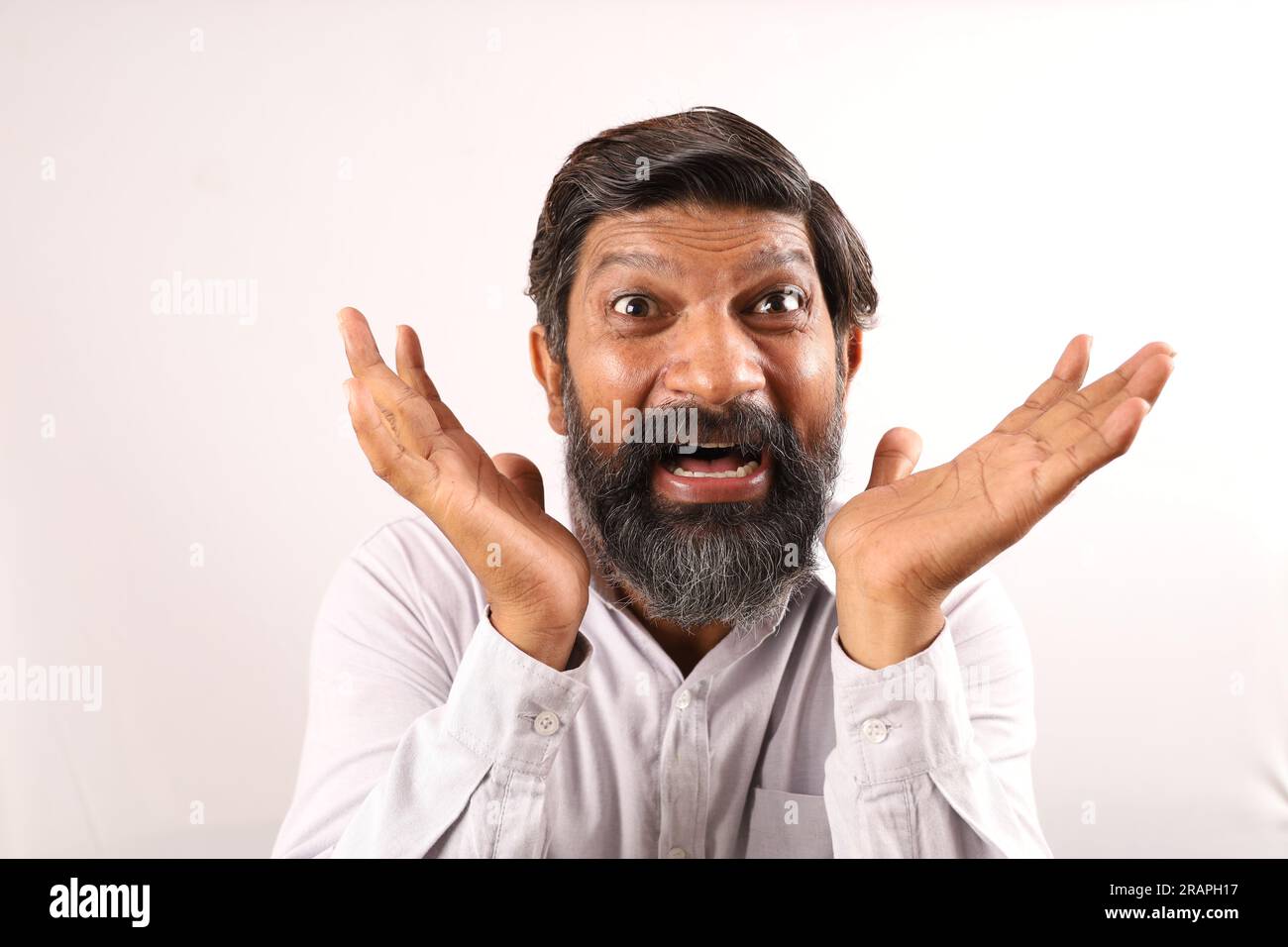 Das Porträt eines indischen bärtigen Mannes überrascht. Flippige Ausdrücke, die das Gefühl von Erfolg und Erfolg darstellen. Stolz darauf sein, Dinge auszuführen. Stockfoto