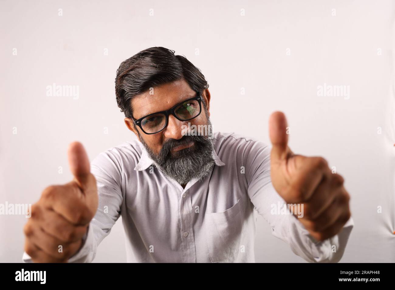 Porträt eines bärtigen Indianers mit Hemd. Unkonventionelle Ausdrücke Sinn für Leistung und Leistung. Daumen hoch. Siegerstrategie. Stockfoto