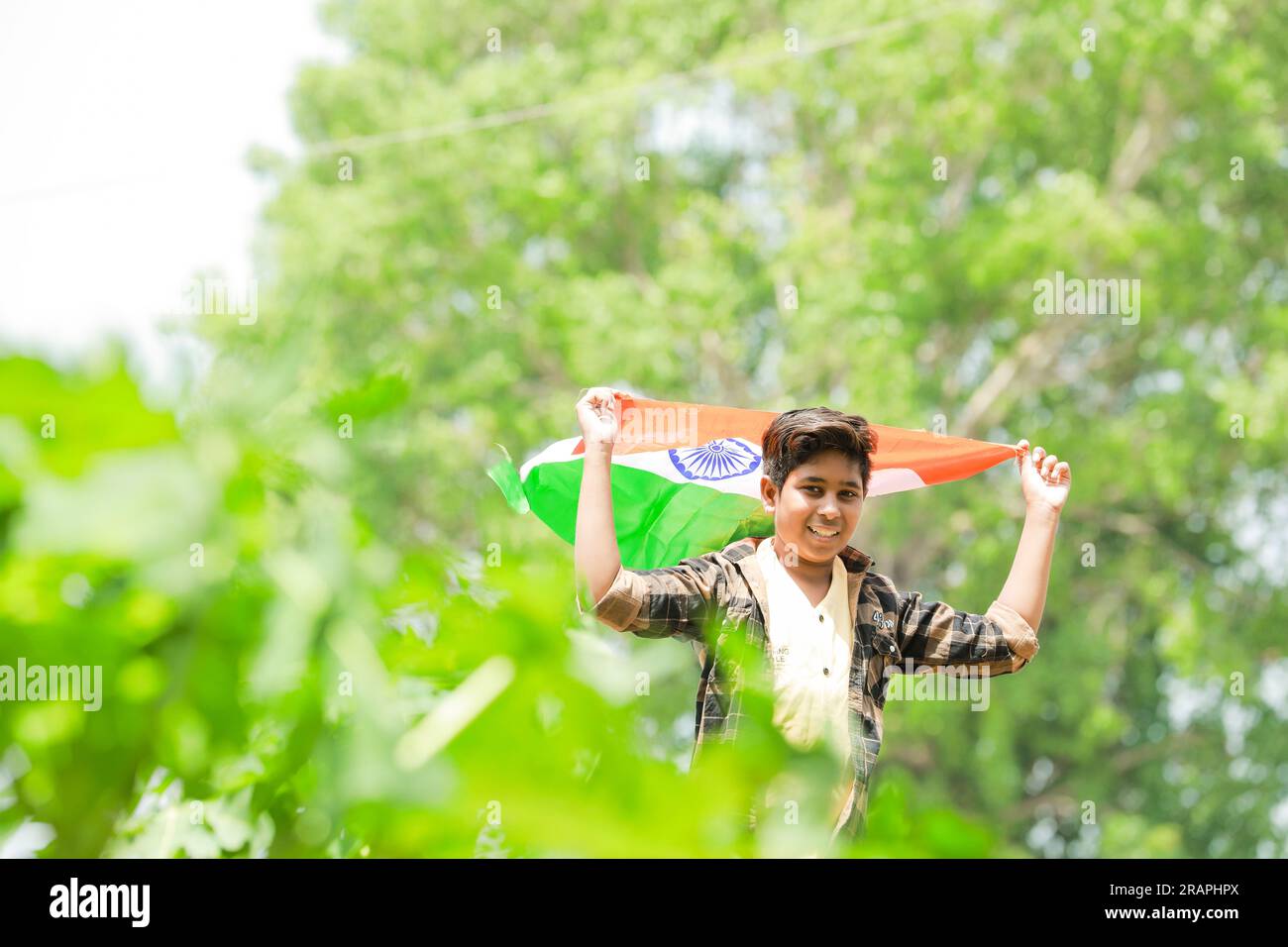 Indischer Junge mit Nationalflagge auf der Farm, glücklicher Junge, Nationalflagge, arme Kinder Stockfoto