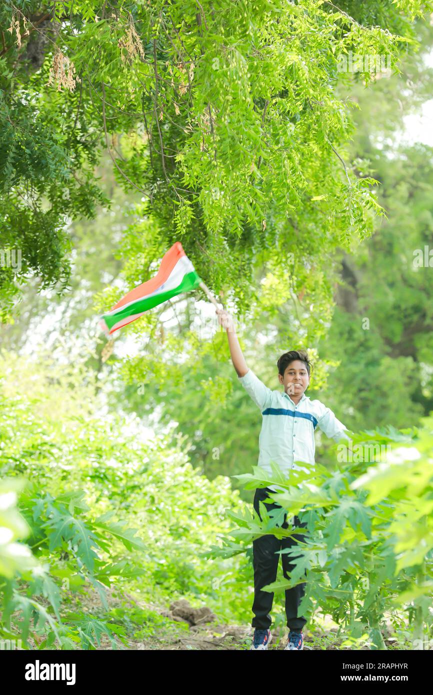 Indischer Junge mit Nationalflagge auf der Farm, glücklicher Junge, Nationalflagge, arme Kinder Stockfoto