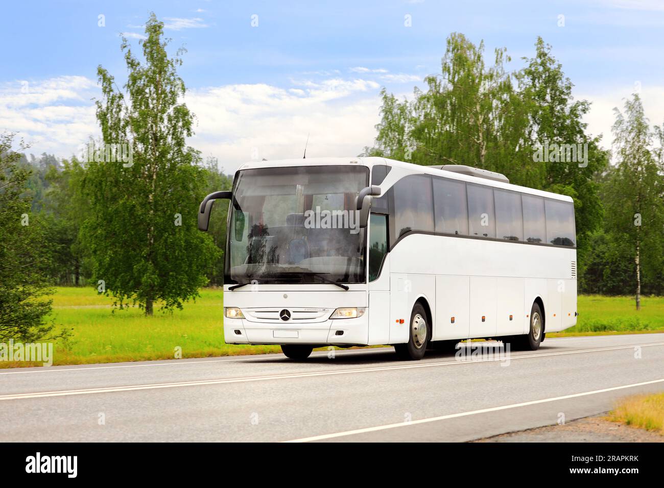 Weißer Mercedes-Benz Tourismo Bus mit hoher Geschwindigkeit auf der Straße am Sommertag, blauer Himmel und Wolken, Platz für Text. Salo, Finnland. 22. Juni 2023. Stockfoto