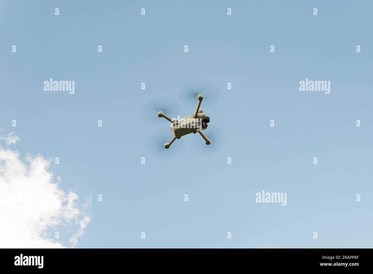 Eine kleine Drohne in der Luft gegen starken Wind gegen den blauen Himmel Stockfoto