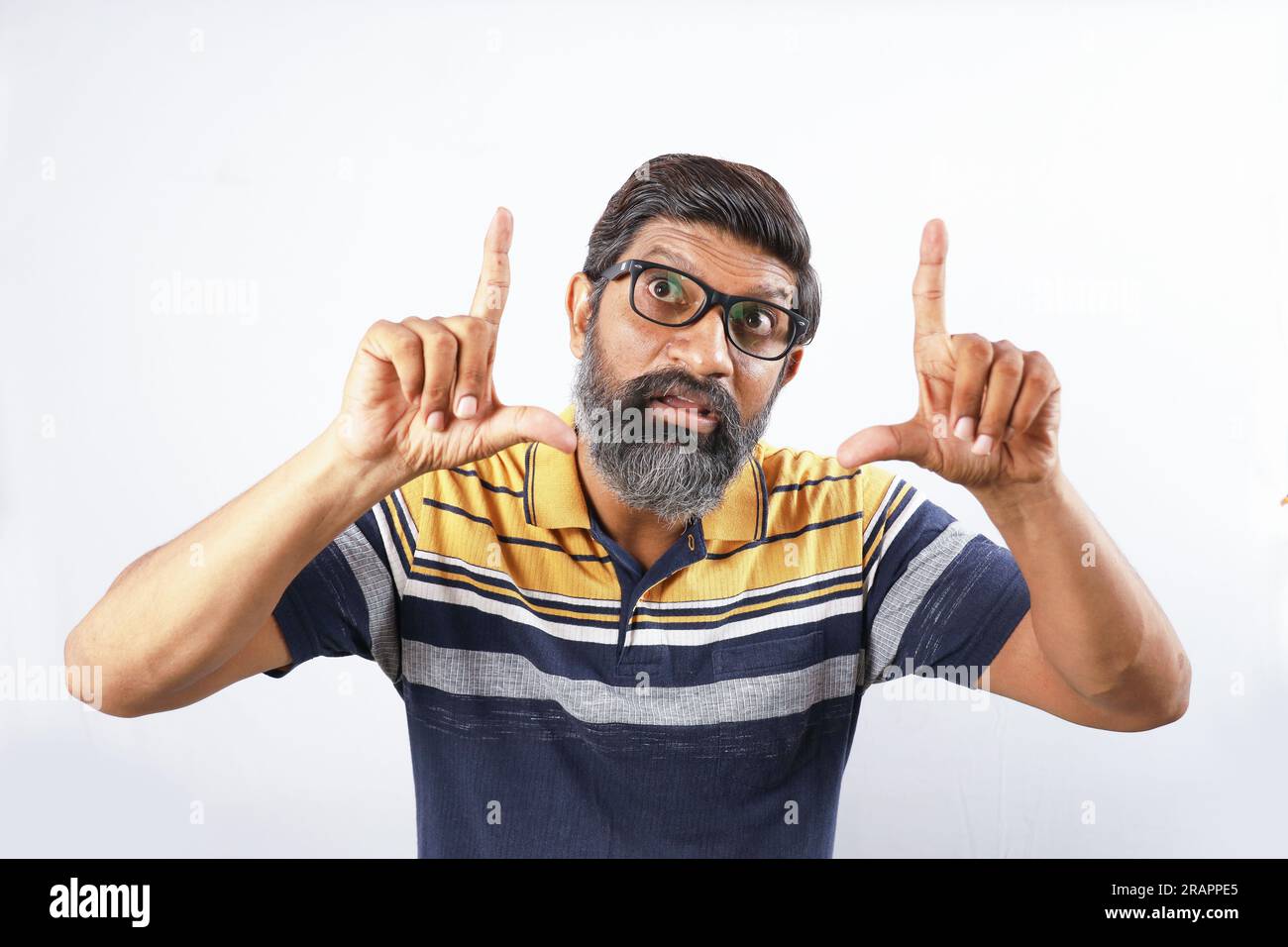 Porträt eines bärtigen Indianers mit Brille und T-Shirt. Seltsame Ausdrücke verzerrten das Gesicht. Ein betäubter Mann, der verschiedene Stimmungen von verrückter Persönlichkeit zeigt. Stockfoto