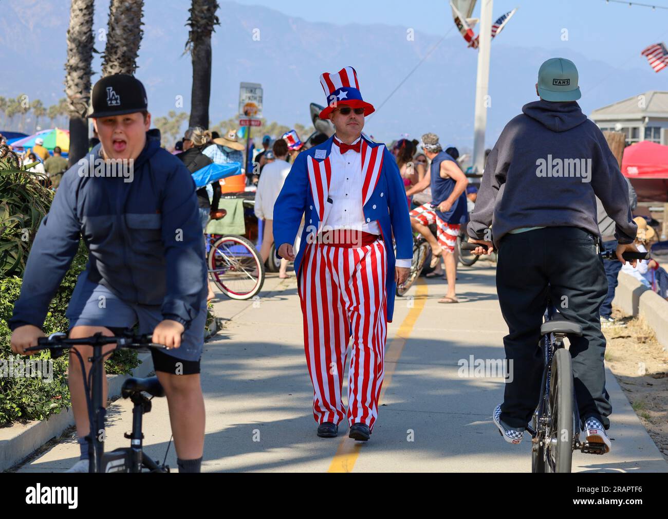 Santa Barbara, Kalifornien, USA, 4. Juli 2023. Onkel Sam geht durch die Feier am 4. Juli 2023 auf Santa Barbara, Kaliforniens Uferpromenade, und ein Junge auf einem Fahrrad sticht aus seiner Tonge heraus. (Kreditbild: © Amy Katz/ZUMA Press Wire) NUR REDAKTIONELLE VERWENDUNG! Nicht für den kommerziellen GEBRAUCH! Stockfoto