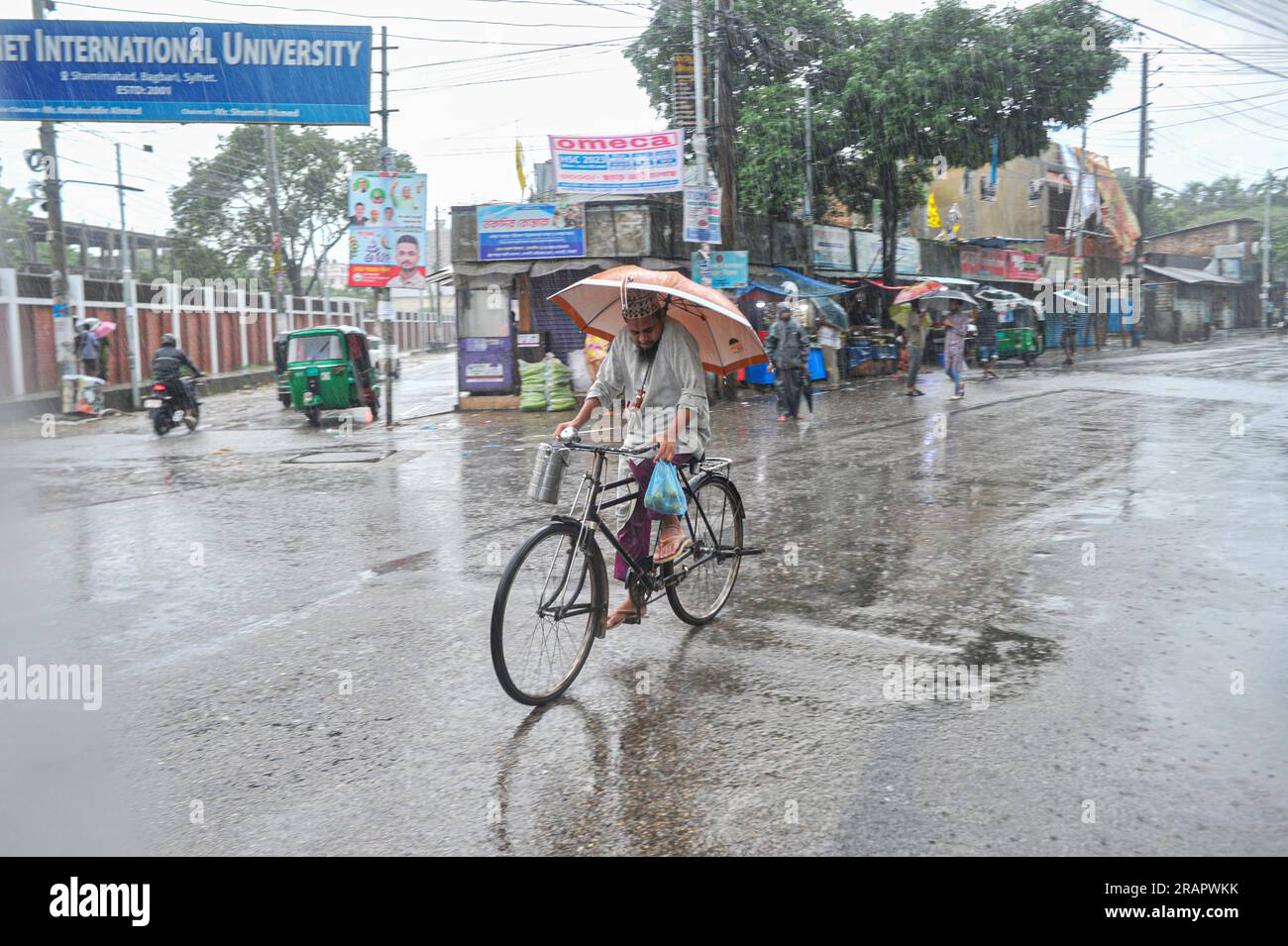 Bei starkem Regen machen sich die Leute auf den Weg. Die unaufhörlichen Regenfälle der letzten Tage haben in Sylhet zu Problemen mit der Wassergewinnung geführt, wobei viele Straßen unter Wasser waren. Aufgrund ungeplanter Baumaßnahmen und eines schlechten Abflusssystems werden diese wasserdurchlässigen Bereiche bei starken Regenfällen und sogar leichten Regenfällen überflutet, so die Einheimischen. Sylhet, Bangladesch. Stockfoto