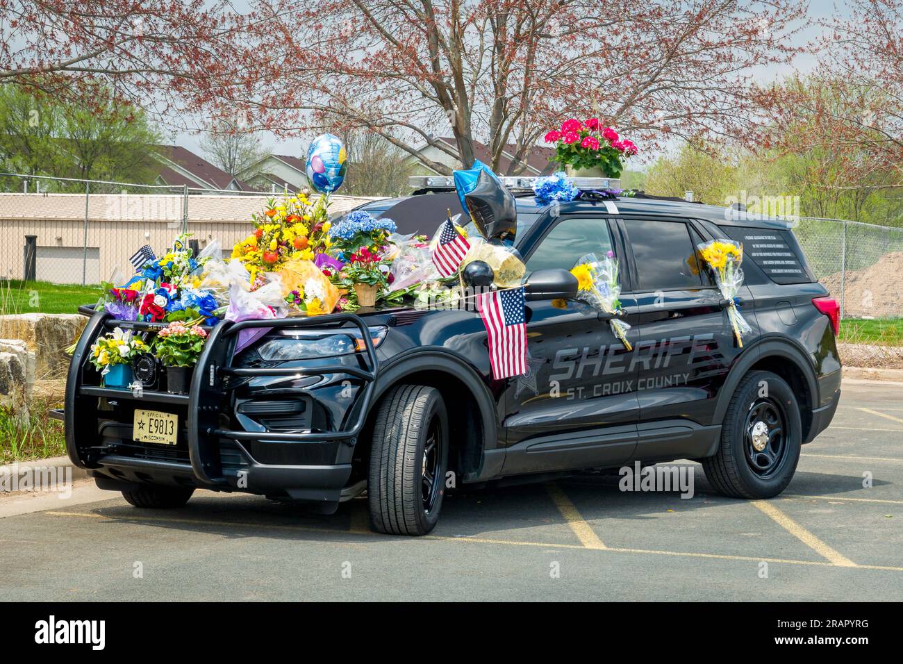 HUDSON, WI, USA - 8. MAI 2023: Falling St. Croix County Sheriff Kaitie Leisings Streifenwagen ist mit Blumen bedeckt. Stockfoto