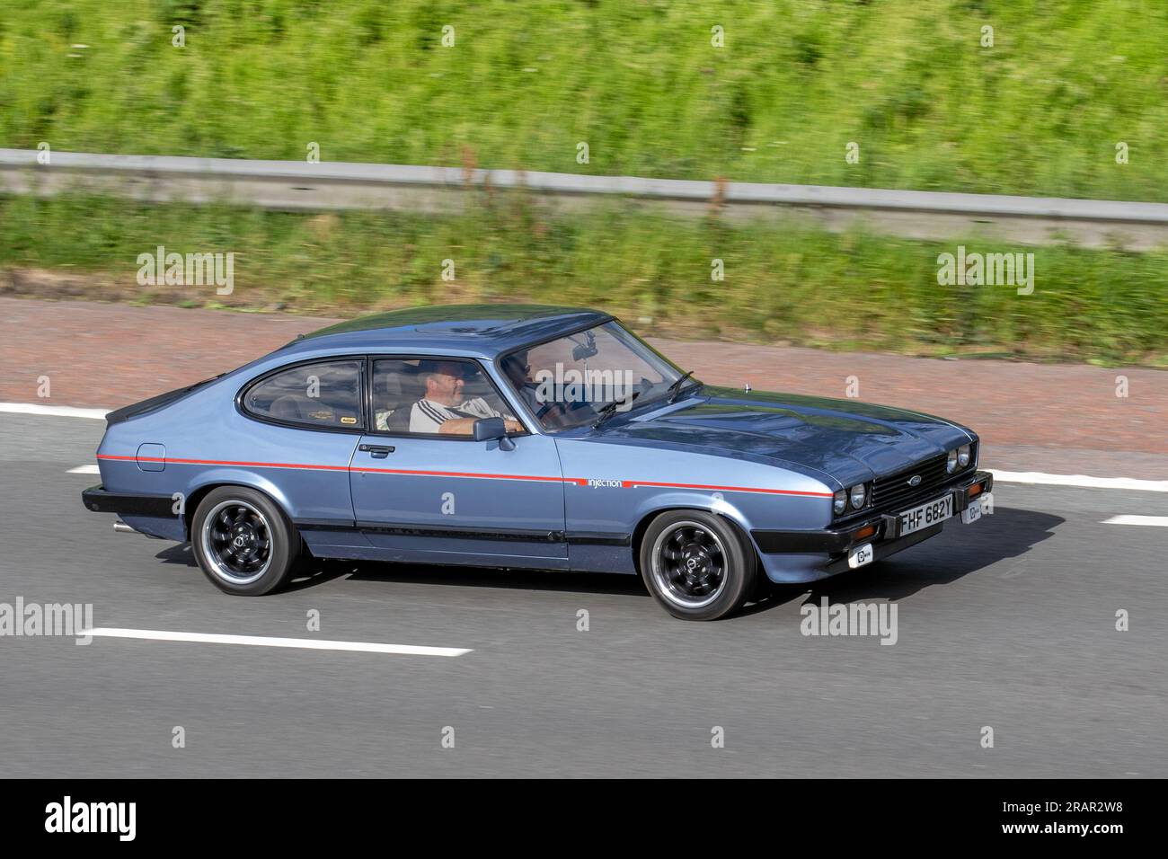 1983 80s Eighties Blue British Ford Capri Injection, V6 Car Hatchback Benzinmotor 2792 cm3; Fahrt mit hoher Geschwindigkeit auf der Autobahn M6 im Großraum Manchester, Großbritannien Stockfoto