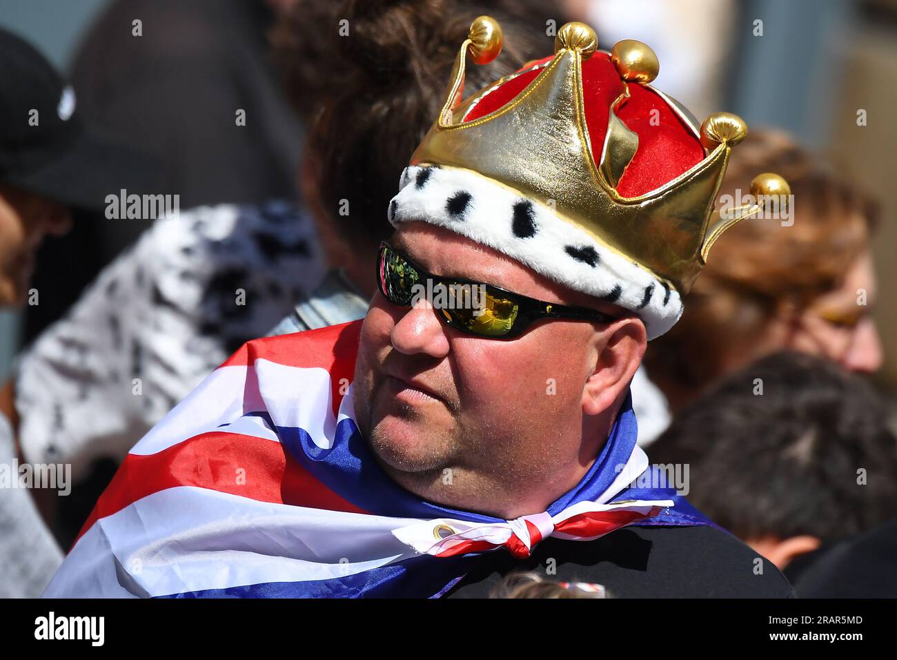 Ein Mitglied der Öffentlichkeit, das mit einer Unionsflagge verkleidet und eine Krone trägt, wartet darauf, die Königliche Prozession in Edinburgh zu beobachten, bevor der Nationaldienst von Thanksgiving und die Widmung für König Karl III. Und Königin Camilla stattfindet und die Ehrung Schottlands in der St. Giles' Cathedral präsentiert wird. Bilddatum: Mittwoch, 5. Juli 2023. Stockfoto