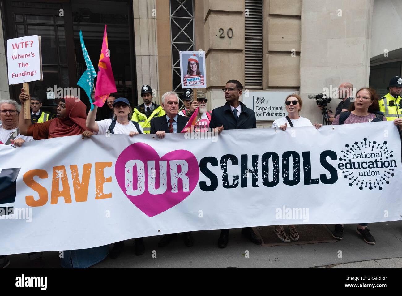 London, Großbritannien. 5. Juli 2023. Streikende Lehrer der National Education Union (neu), zusammen mit dem Labour-Abgeordneten John McDonnell, stehen hinter einem Banner mit der Aufschrift „Save our Schools“ außerhalb des Bildungsministeriums, während sie zwei Tage Streiks beginnen, in denen sie zu höheren Löhnen als Inflationsniveau und einer besseren Finanzierung der Schulen aufrufen. Kredit: Ron Fassbender/Alamy Live News Stockfoto