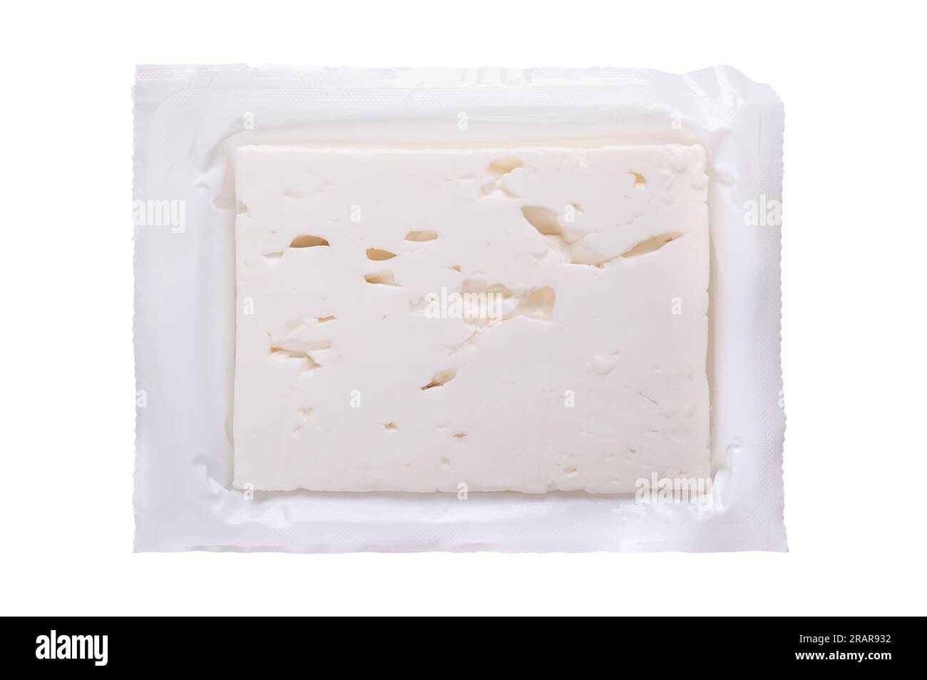 Griechischer Feta-Block, gebrannter Käse, in seiner geöffneten Originalverpackung aus Plastik. Käse, in Salzlake gereift, mit weicher und feuchter Textur. Stockfoto