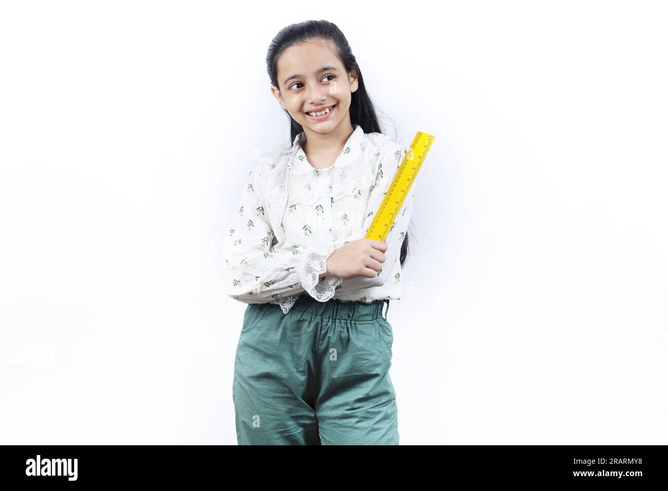 Junge Lehrerin. Porträt eines glücklichen indischen Teenagers, das eine Messskala in der Hand hält und eine Brille trägt. Monitorkonzept der jungen Klasse. Stockfoto