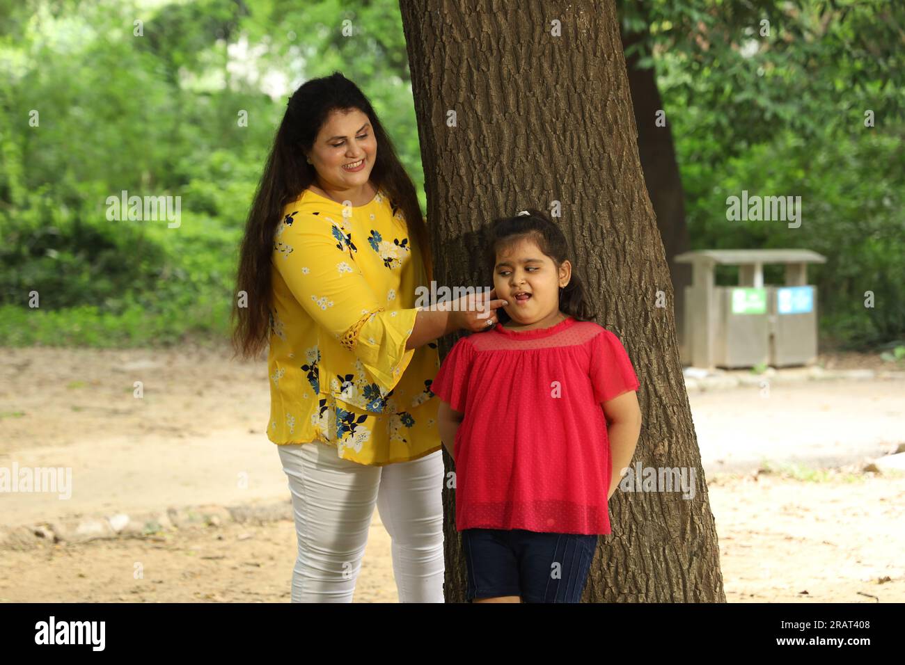 Glückliche Mutter und Tochter genießen ihre gemeinsame Zeit in einem öffentlichen Park. Alleinerziehende Mutter spielt mit ihrer Tochter in grüner und sauberer Atmosphäre. Stockfoto
