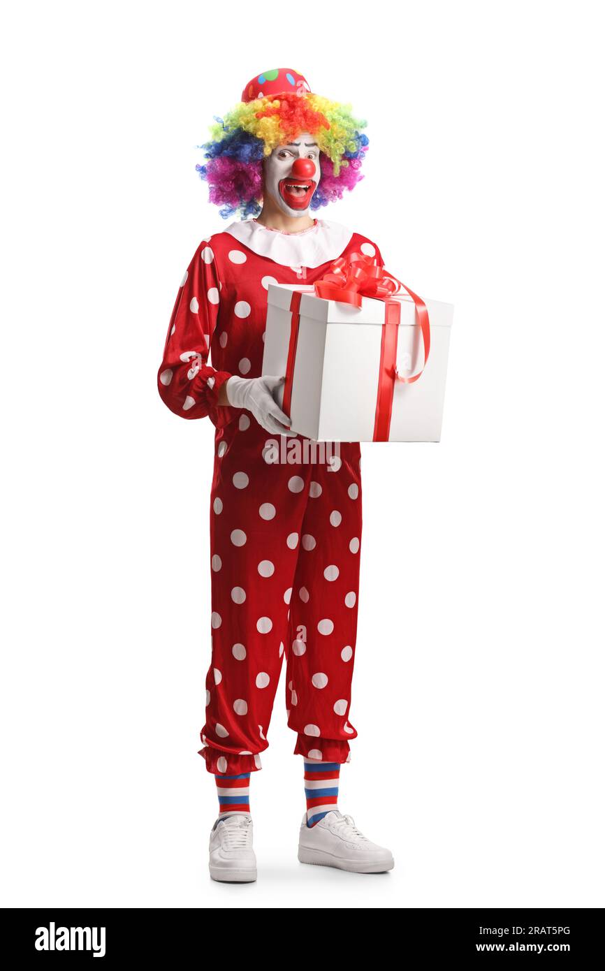 Porträt eines Clowns in einem roten Kostüm mit einer Geschenkbox isoliert auf weißem Hintergrund Stockfoto